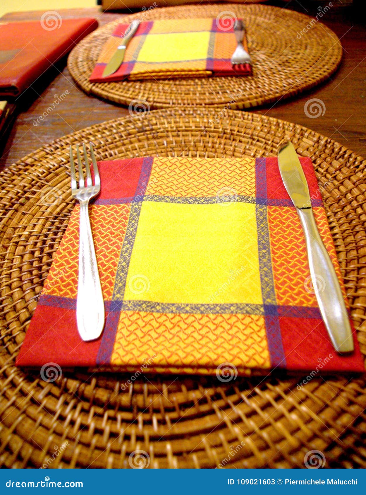 Restaurant Table with Red, Orange and Yellow Placemat and Soft L Stock