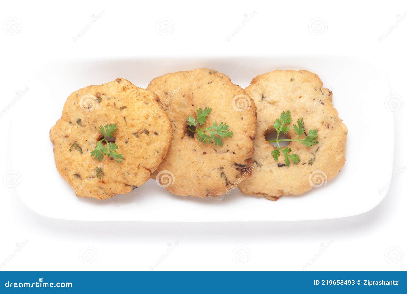 plain dry three-piece dahi badhe for preparation of chaat, garnished with cumin and green fresh coriander in a white plate.