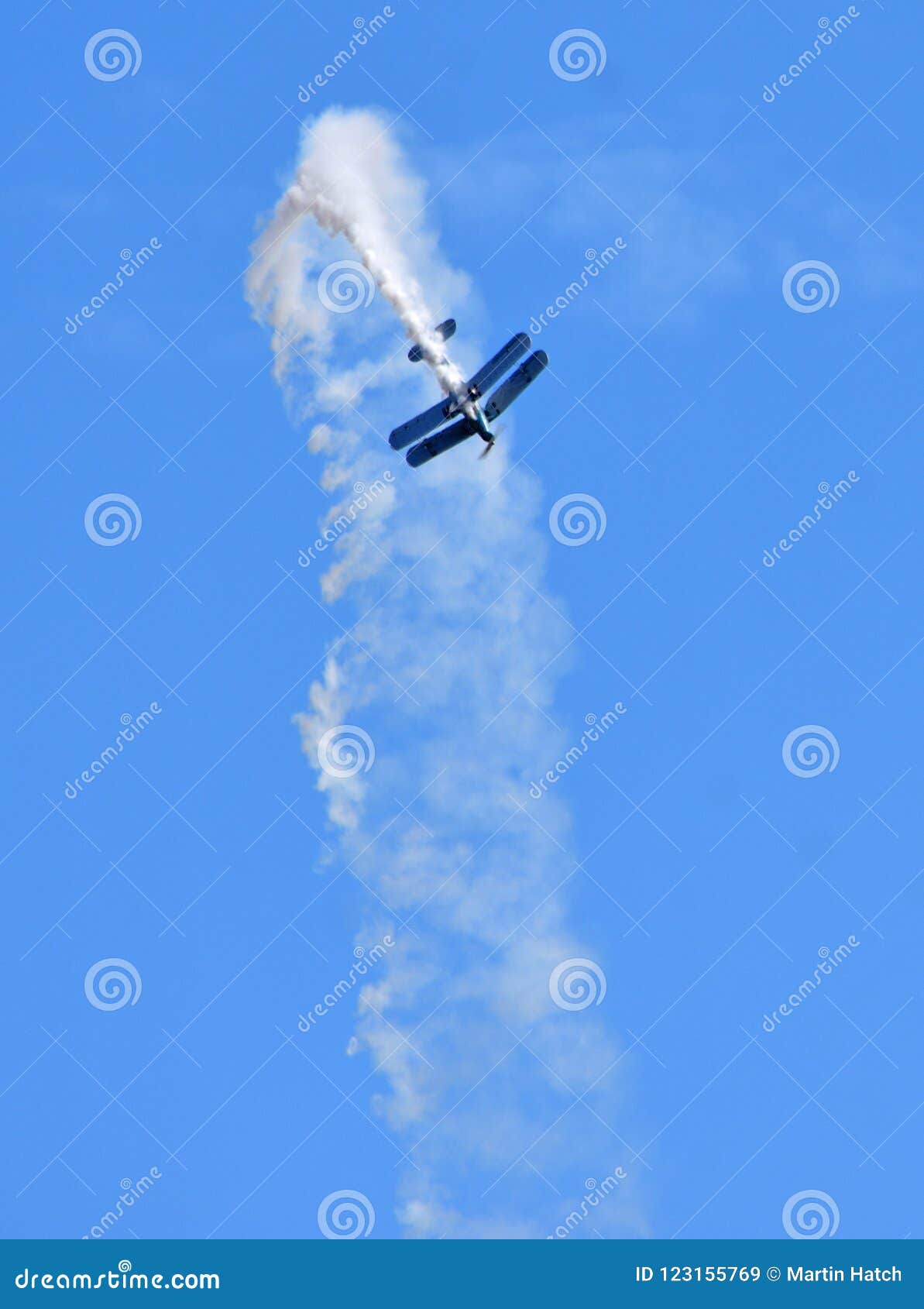 by-plane preforming aerobatics with smoke trail.