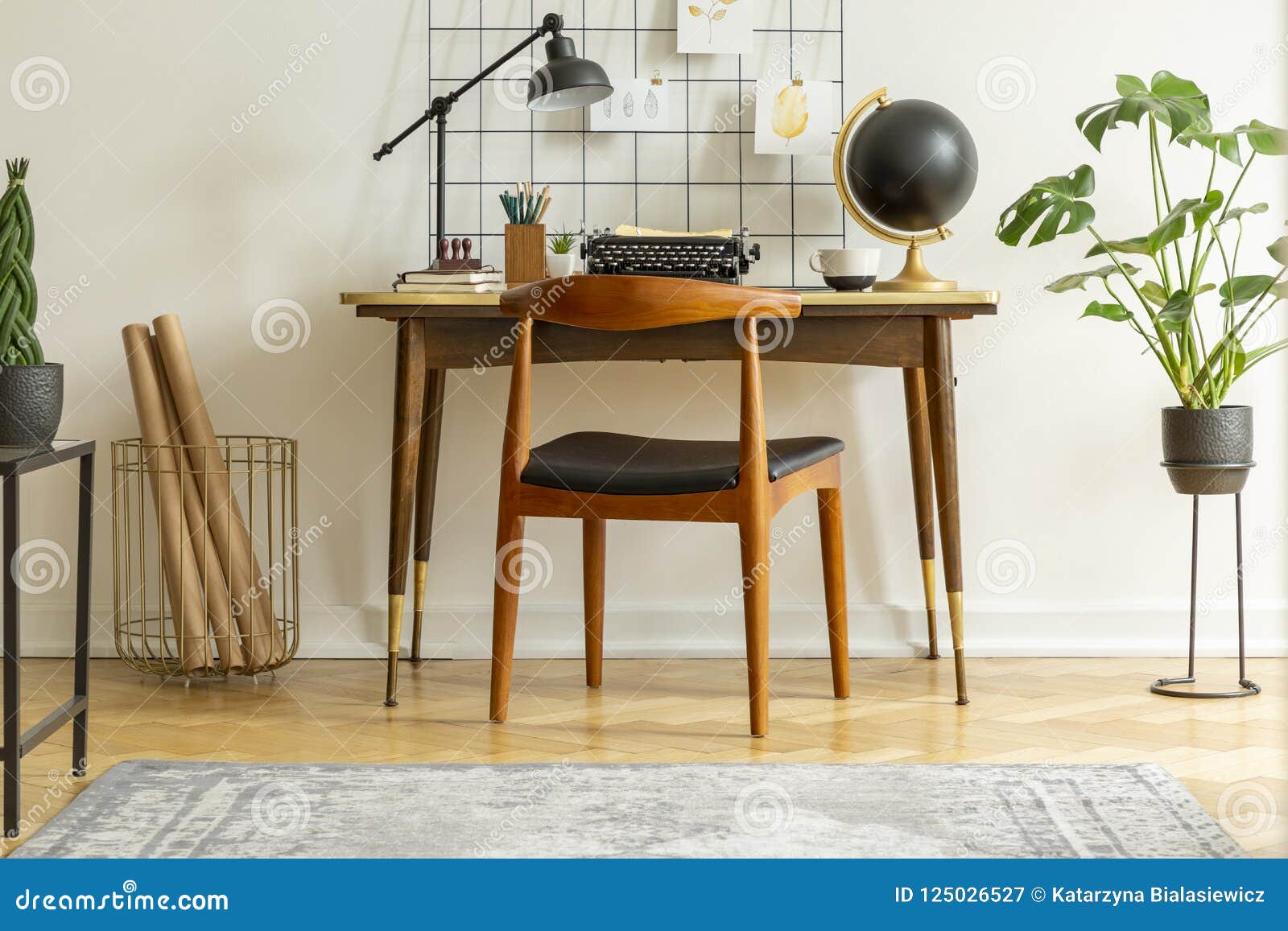 Plant Next To Chair And Desk With Lamp Typewriter And Globe In