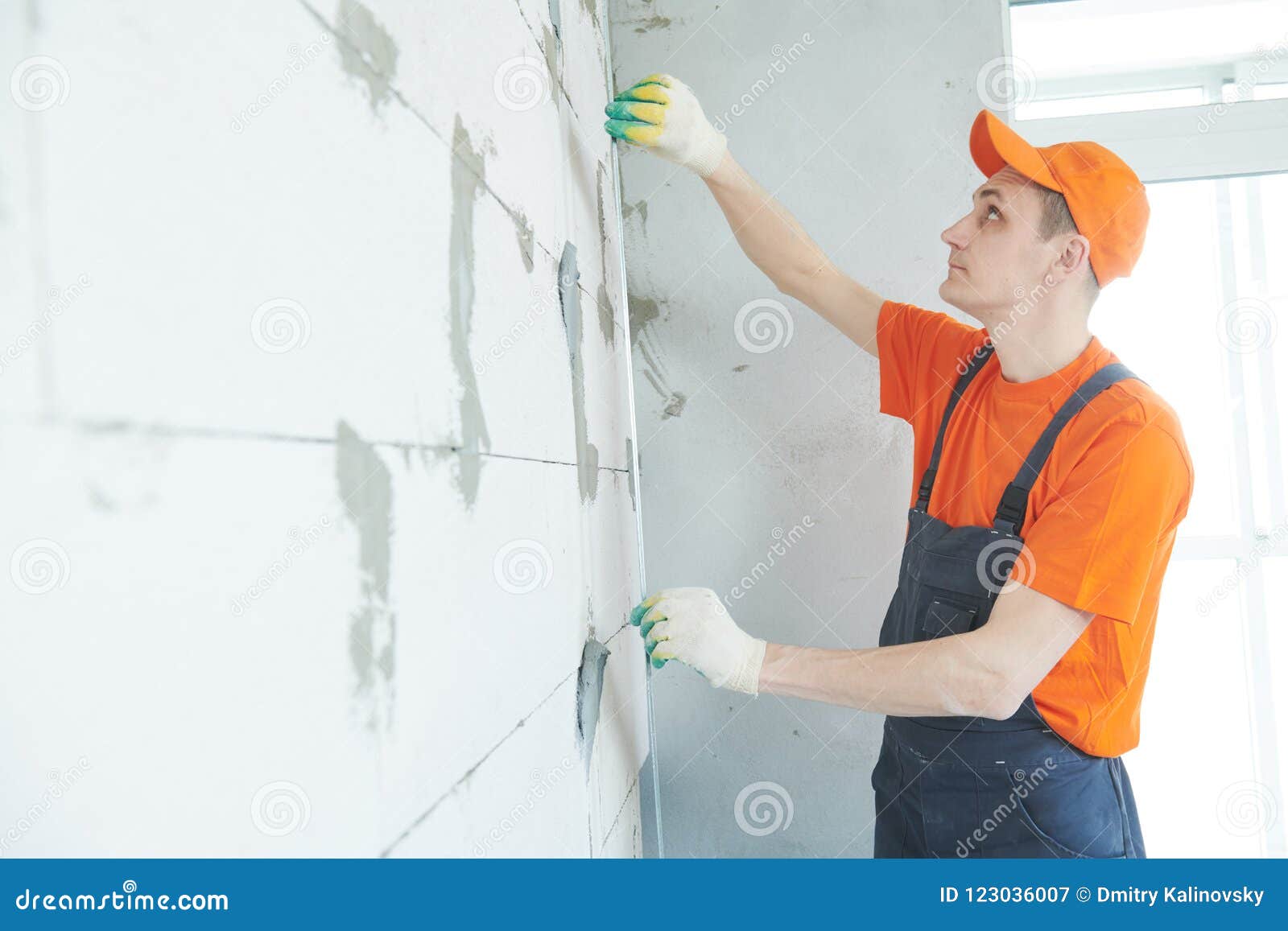 plasterer installing screed on wall for plastering