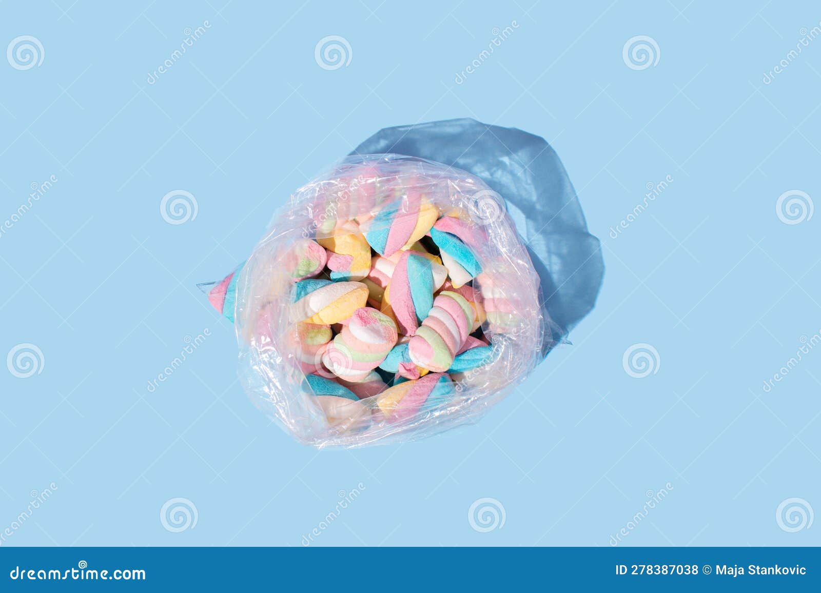 Plastic Bag Full of Colorful Marshmallow on Pastel Blue Background