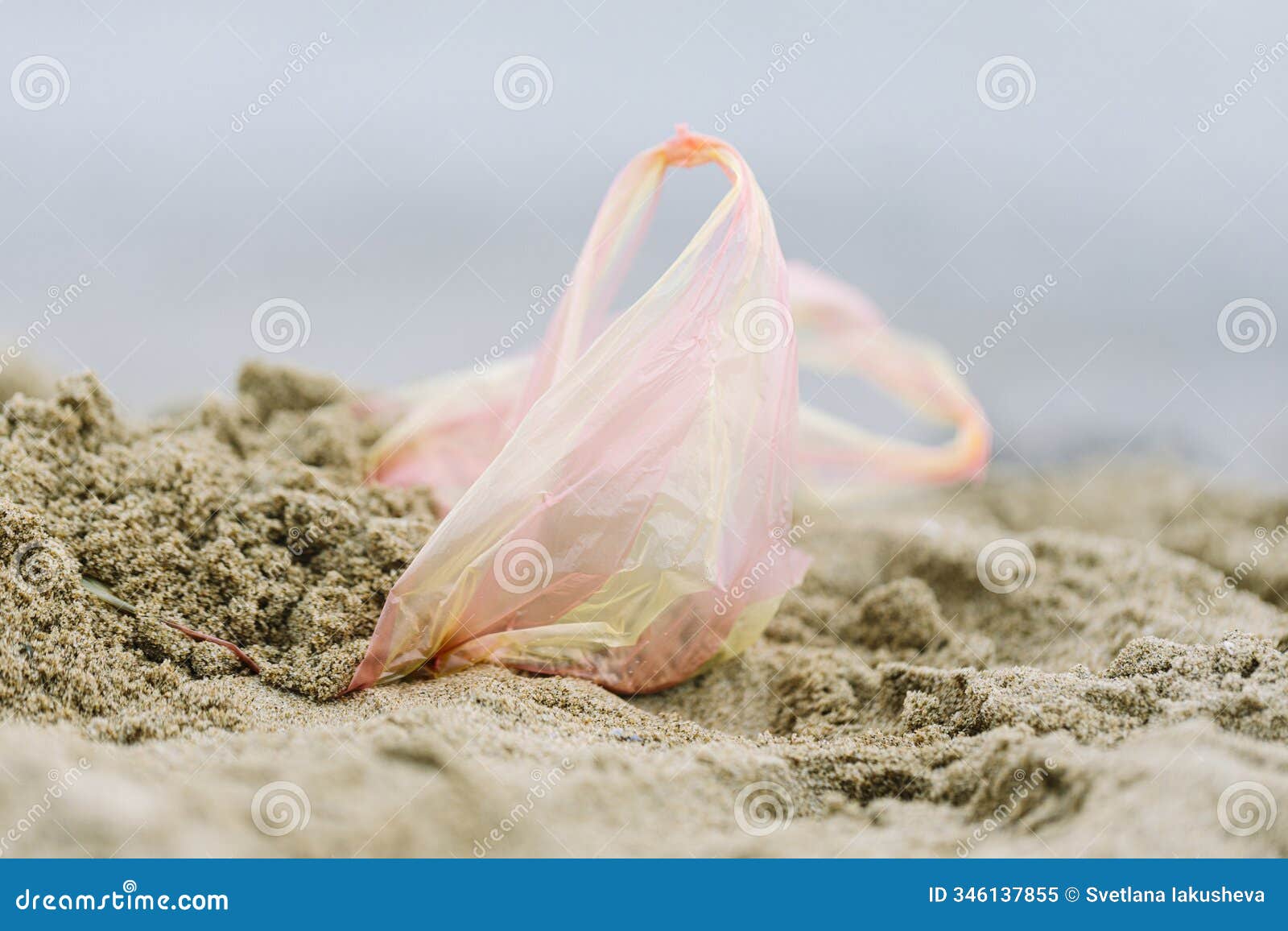 plastic bag left on sandy beach