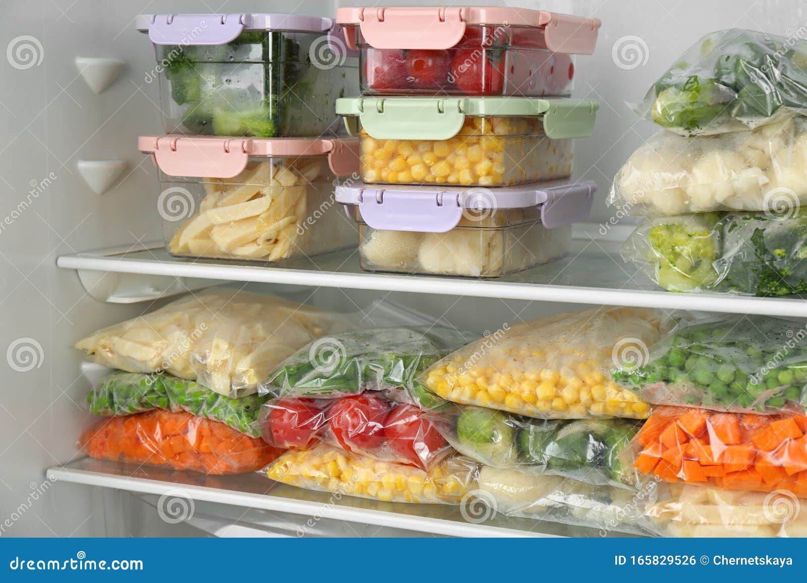 Plastic Bags and Containers with Frozen Vegetables in Refrigerator