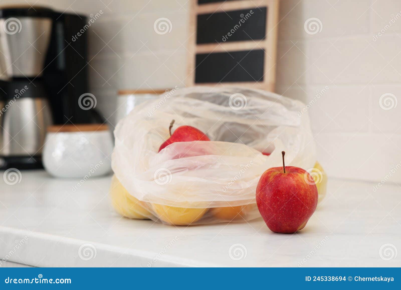 Plastic Bags with Different Fresh Products on White Countertop in