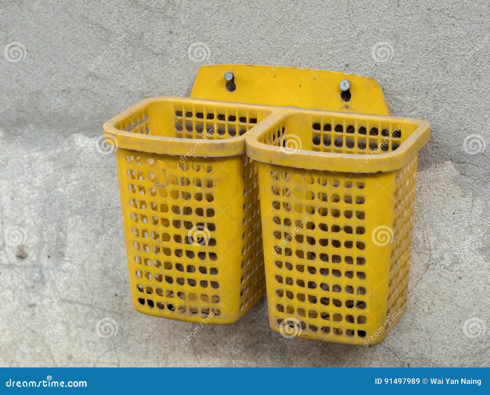 COLOR PHOTO OF PLASTIC BASKET SCREWED ON CONCRETE WALL