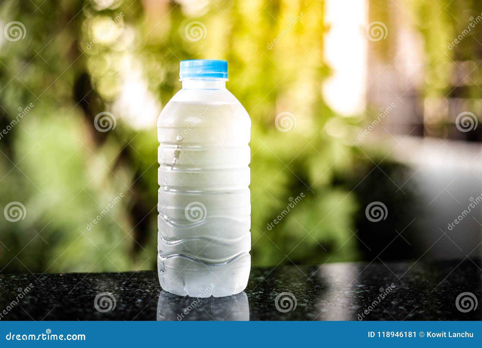 Plastic Bottle of Drink Water and Reflection on Table with Sunlight