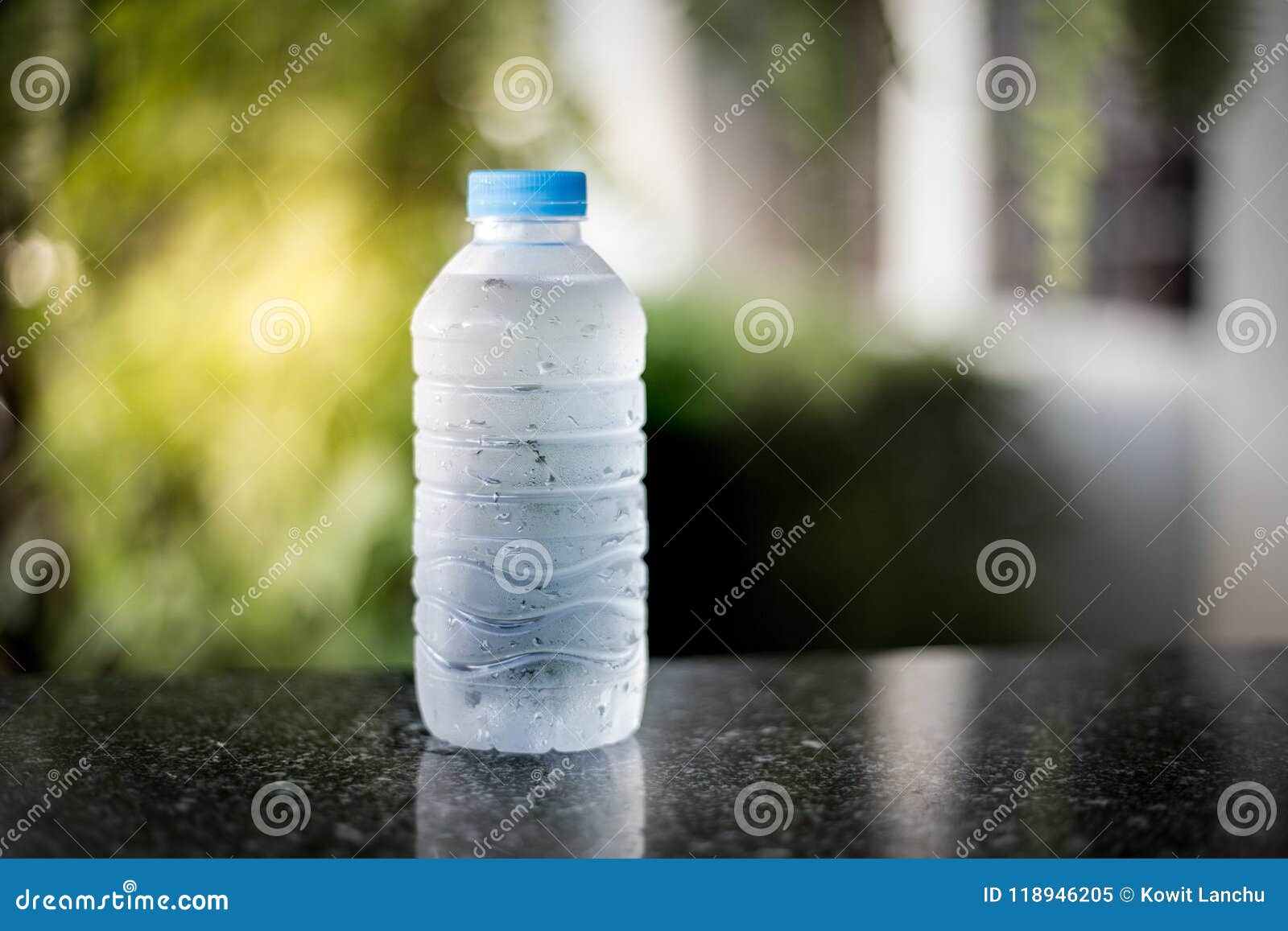 Plastic Bottle of Drink Water and Reflection on Table with Sunlight at