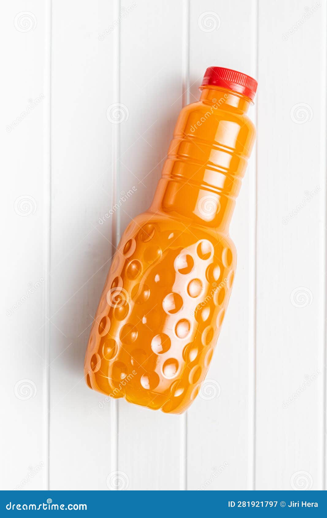A Plastic Bottle of Fruit Juice. Orange Juice on White Table. Top View