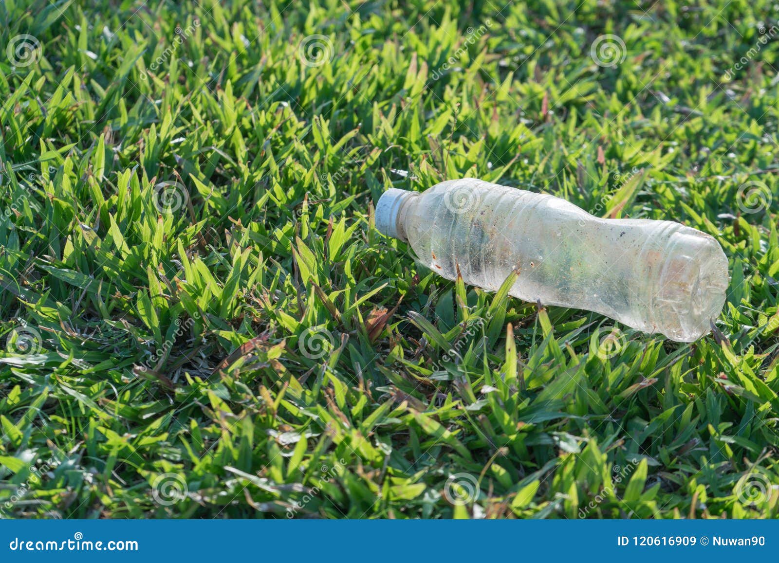 Llenando de orina y semen una botella en la hierba