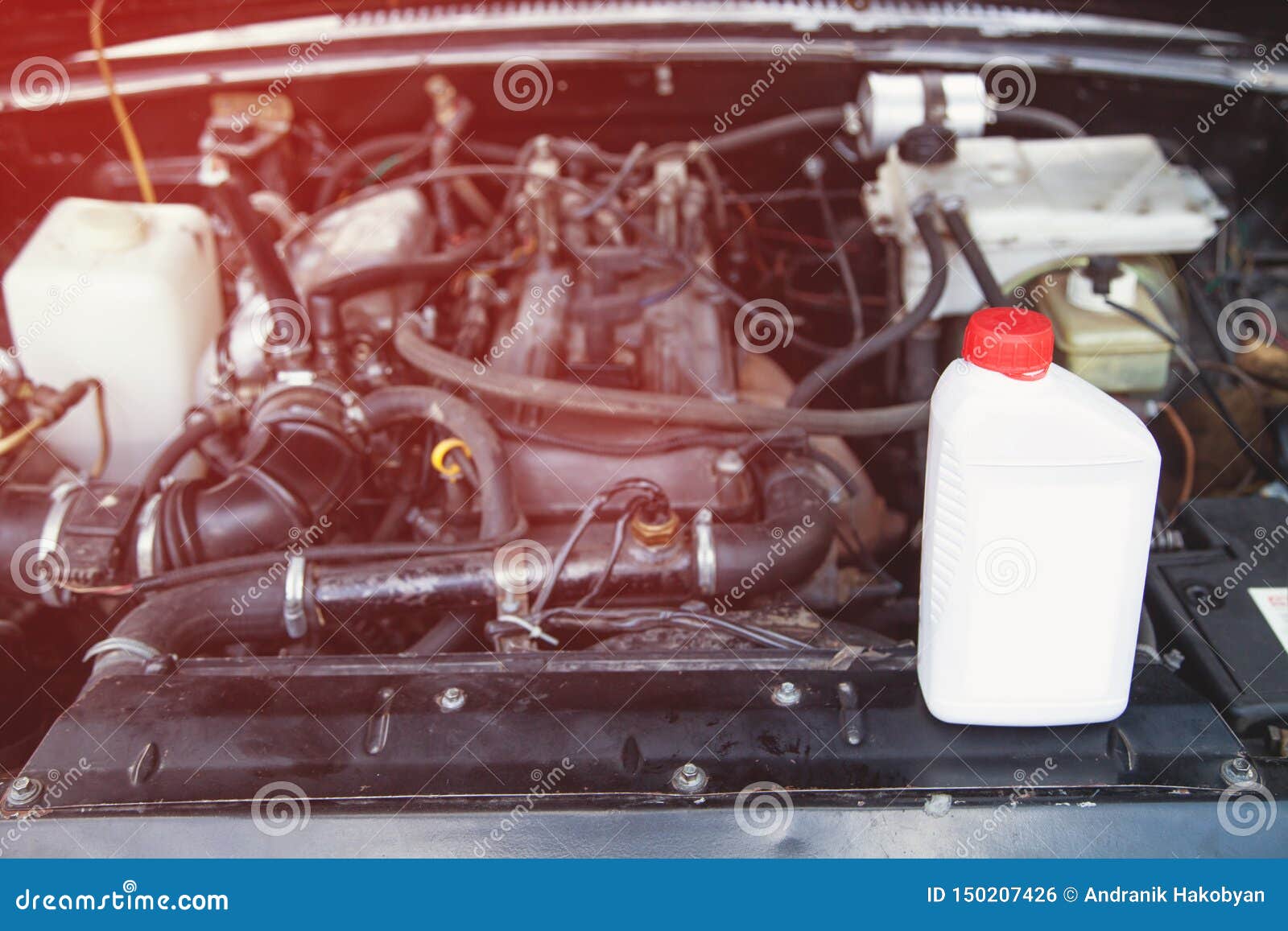Plastic Bottle of Machine Oil with a Car Motor Stock Photo Image of