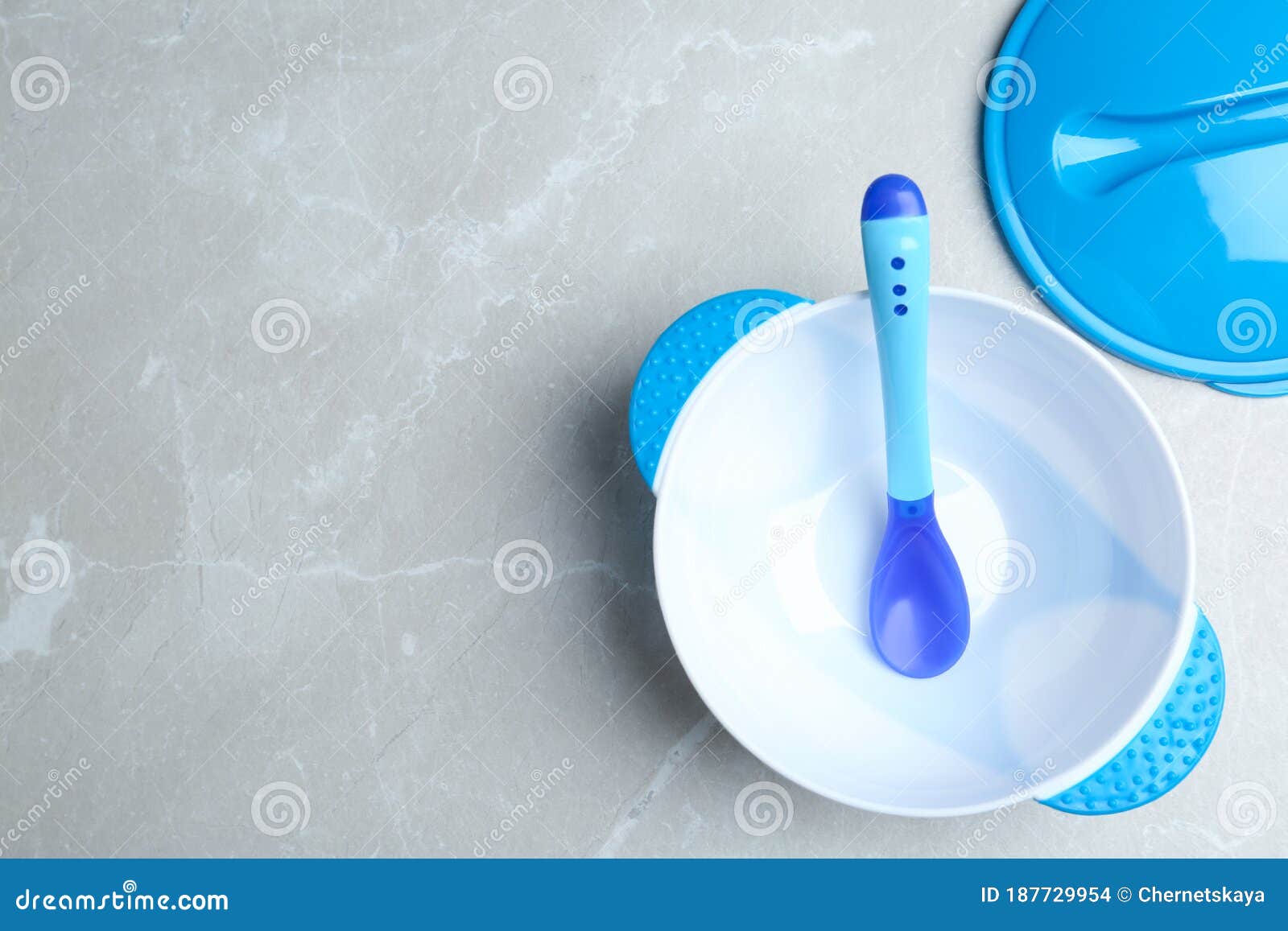 Plastic Bowl and Spoon on Light Marble Table, Flat Lay with Space for