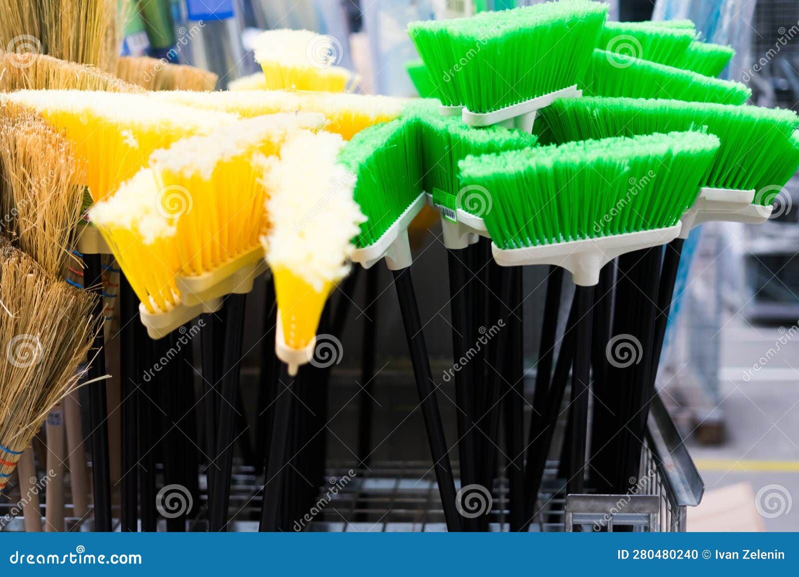 Plastic Brushes for Cleaning Premises. Assortment of Multicolored Brooms in the Store. Closeup