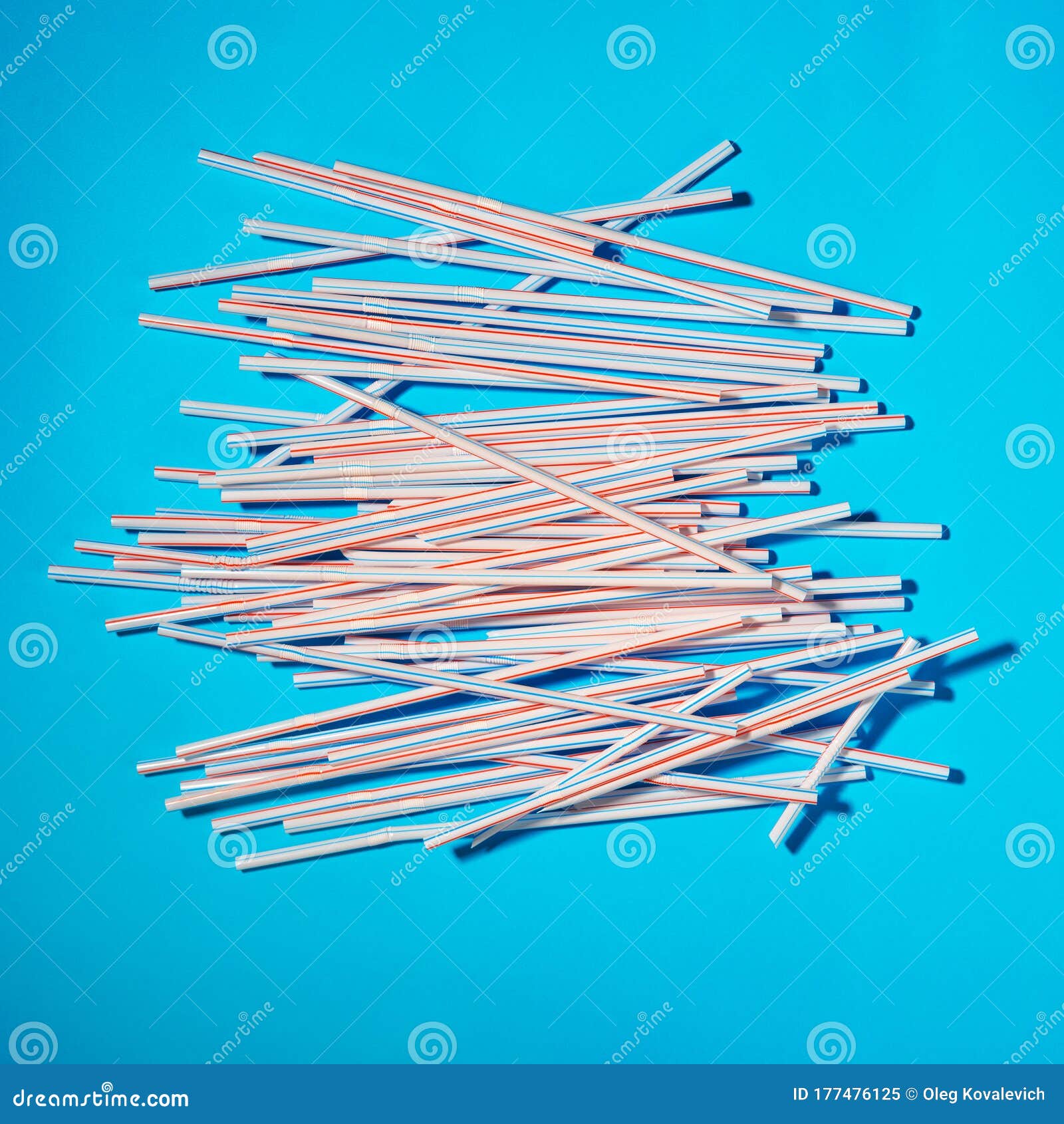Plastic Cocktail Straws Scattered on a Blue Background Stock Image