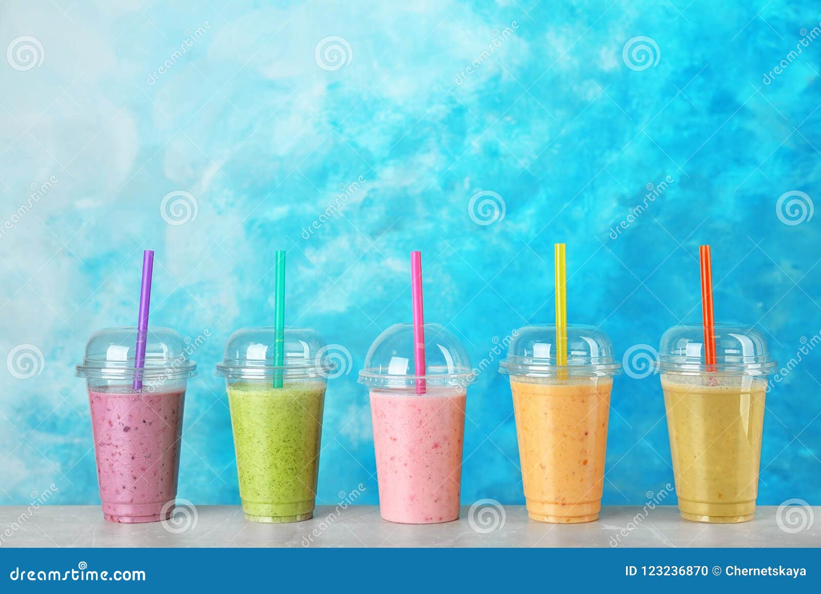 https://thumbs.dreamstime.com/z/plastic-cups-smoothies-table-plastic-cups-smoothies-table-against-color-background-123236870.jpg