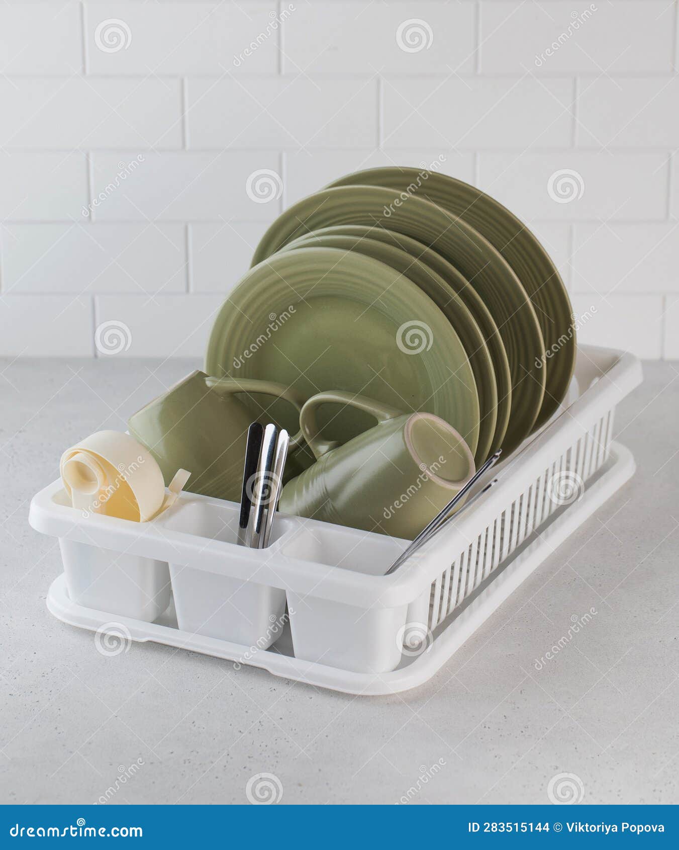 A Plastic Dish Drying Rack in the Kitchen with Clean Dishes Inside