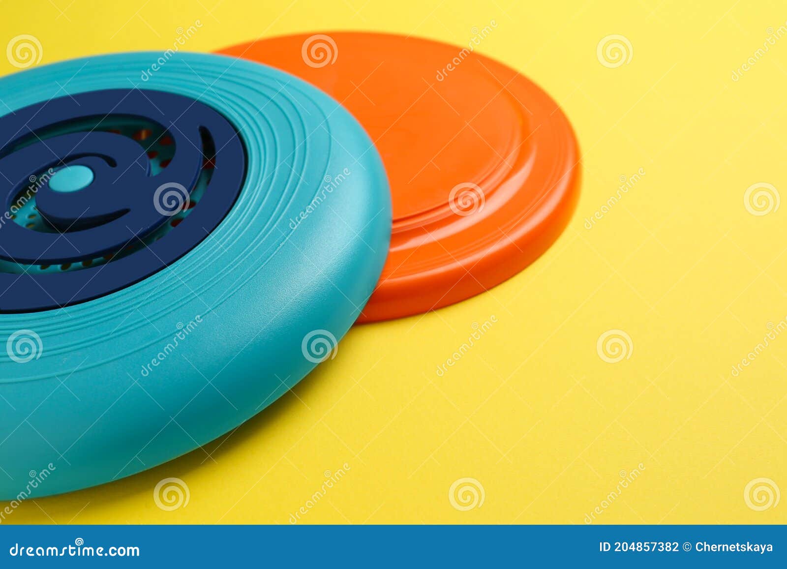 Plastic Frisbee Disks on Yellow Background, Closeup Stock Photo Image