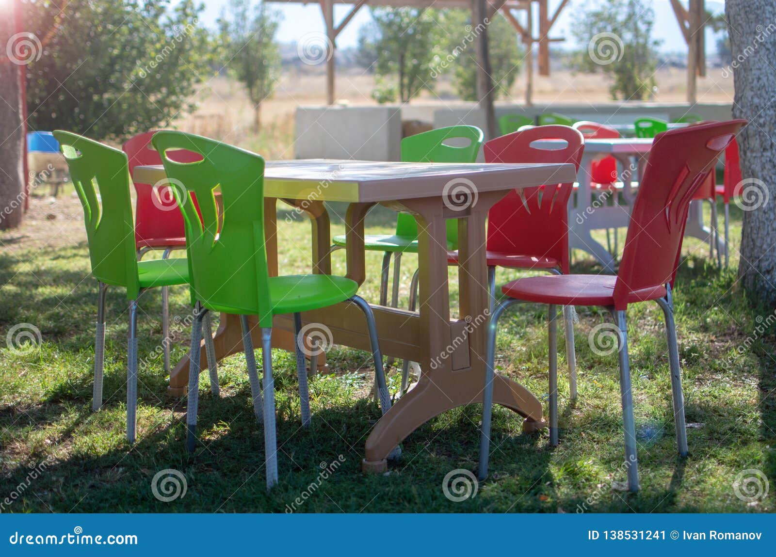 Plastic Table And Chairs Outside In A Garden On Green Lawn Stock