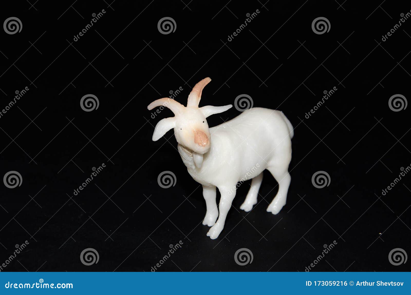Plastic Toy Horned Goat on a Black Background. Realistic Toy Copy Space