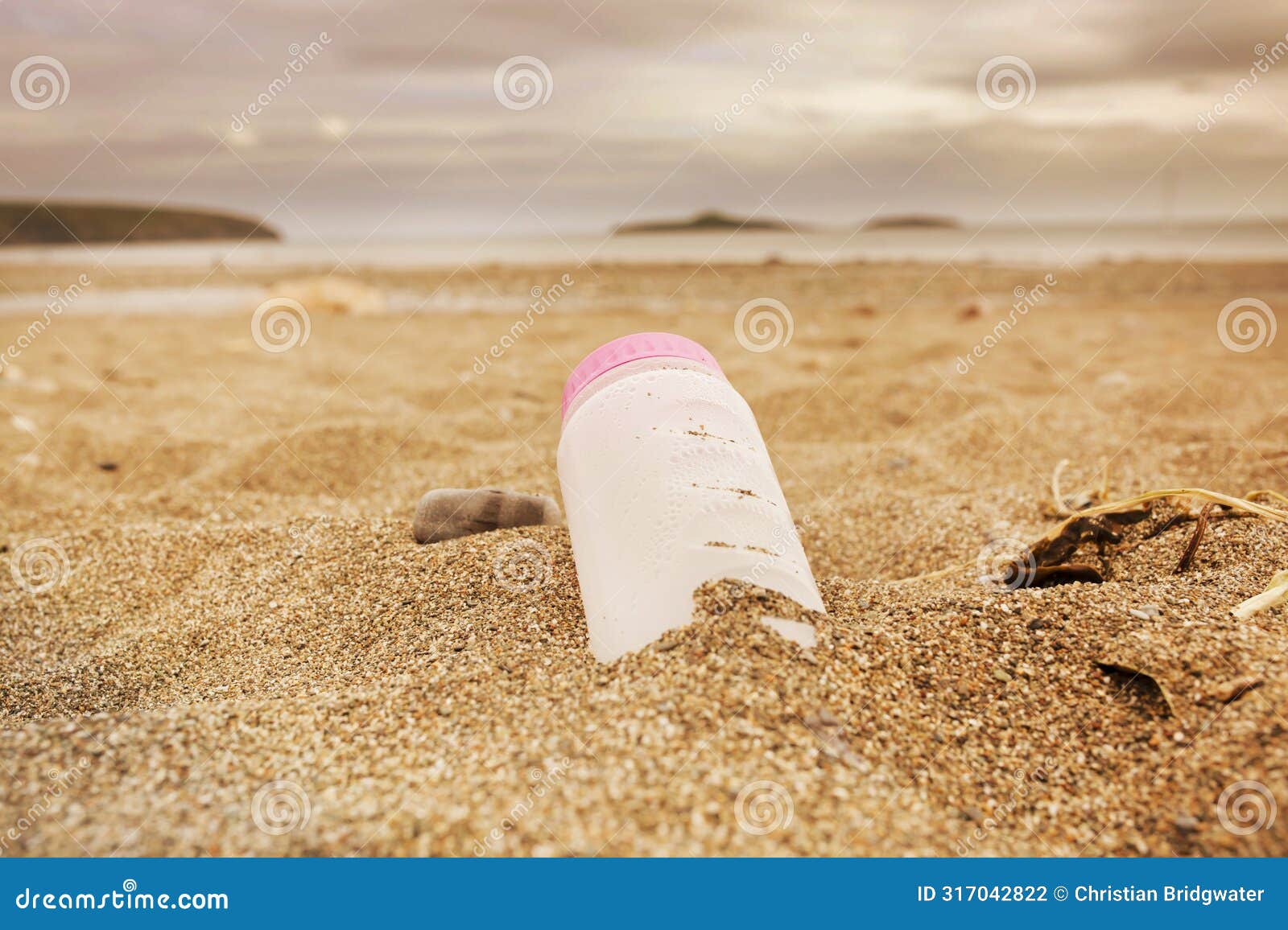 plastic water bottle left discarded on a beach in wales. plastic waste in our oceans