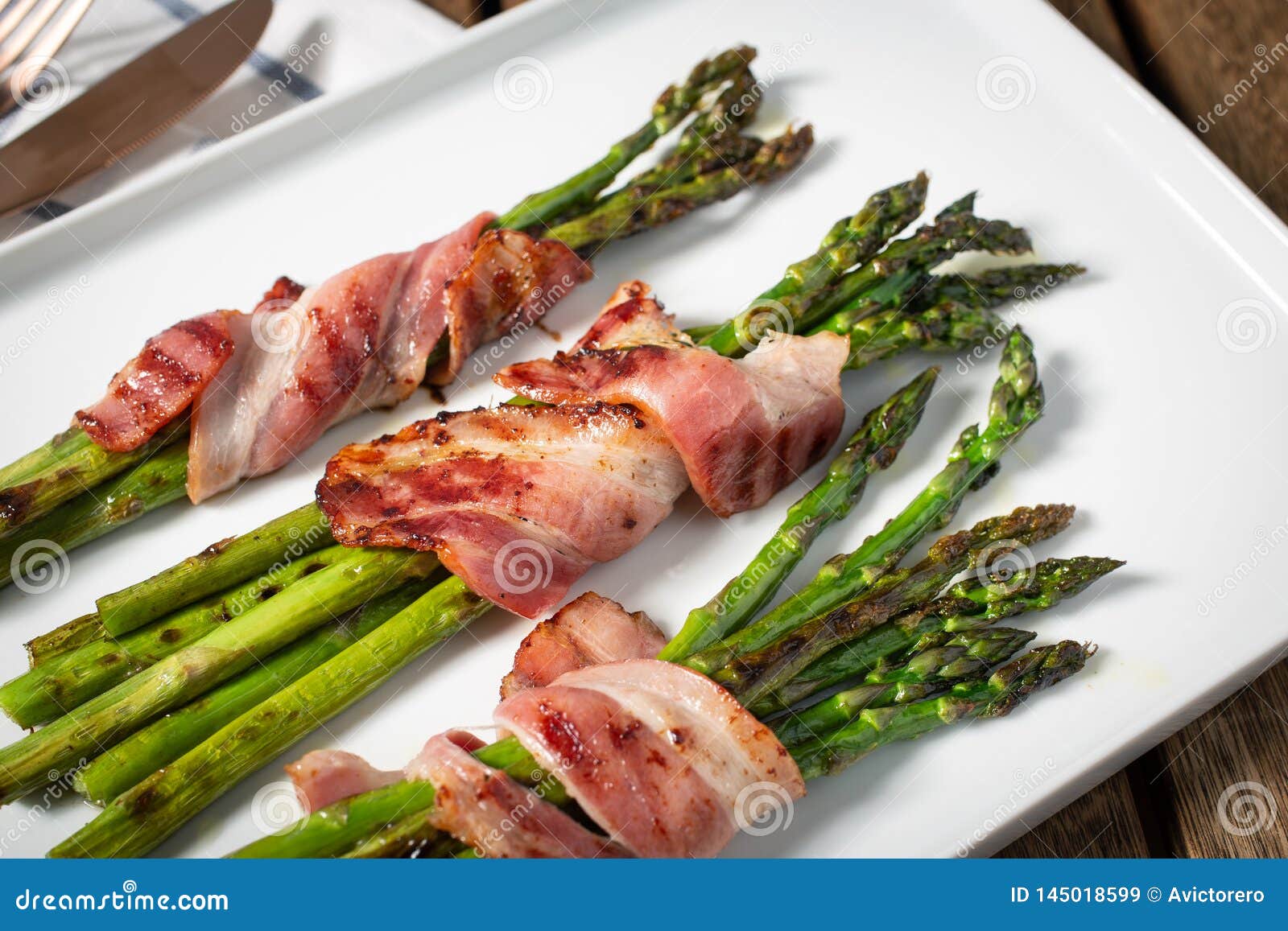 cooked asparagus with wrapped bacon on plate
