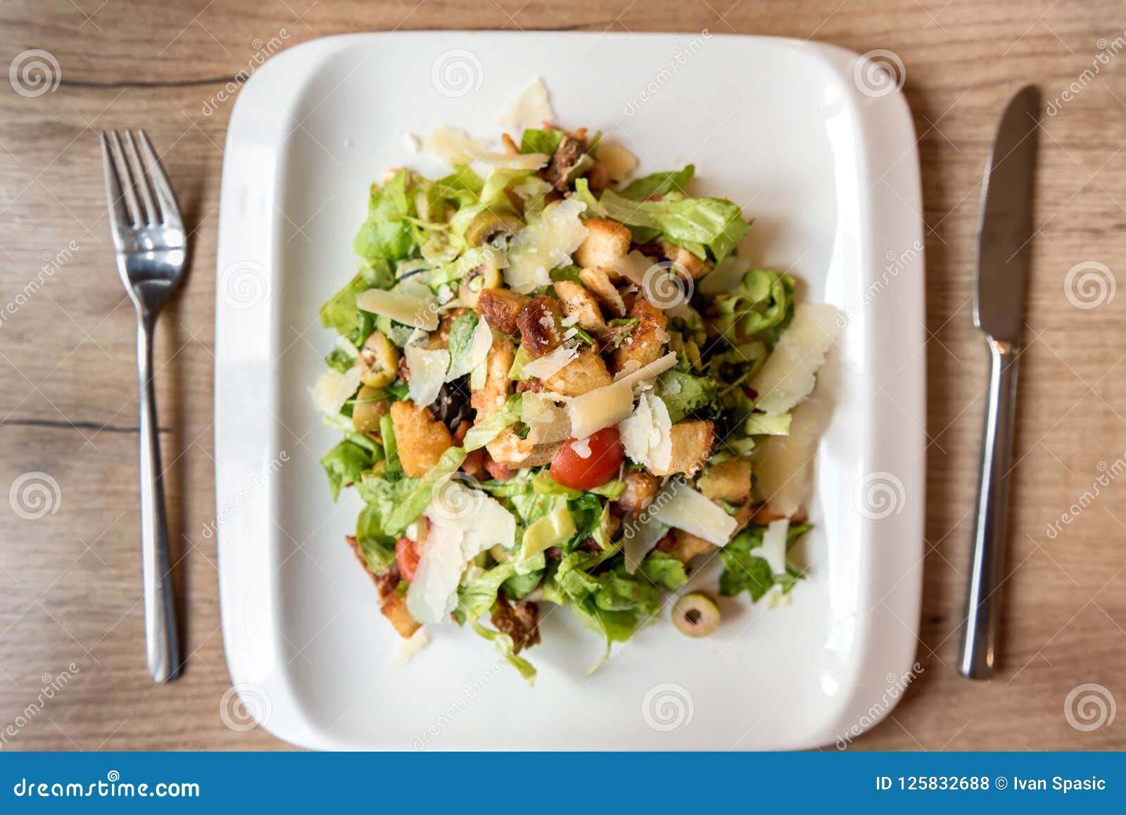 plate of caesar salad on wooden table