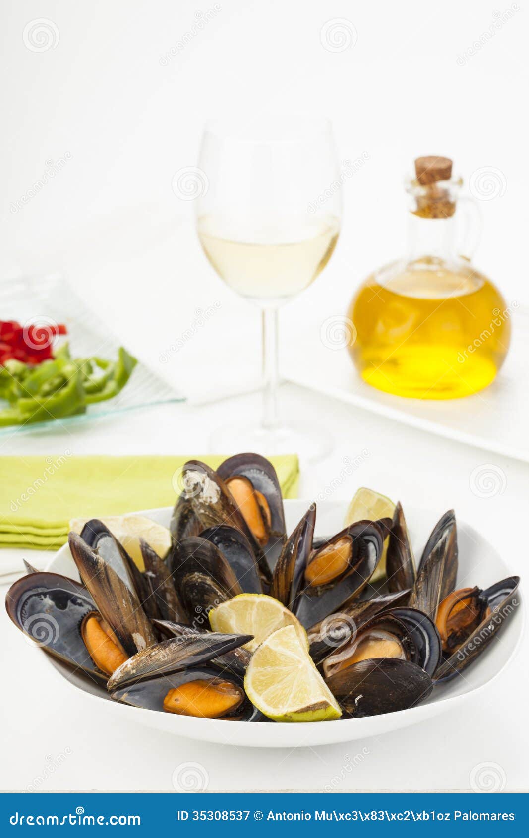 plate of coocked mussels with lemon  over white
