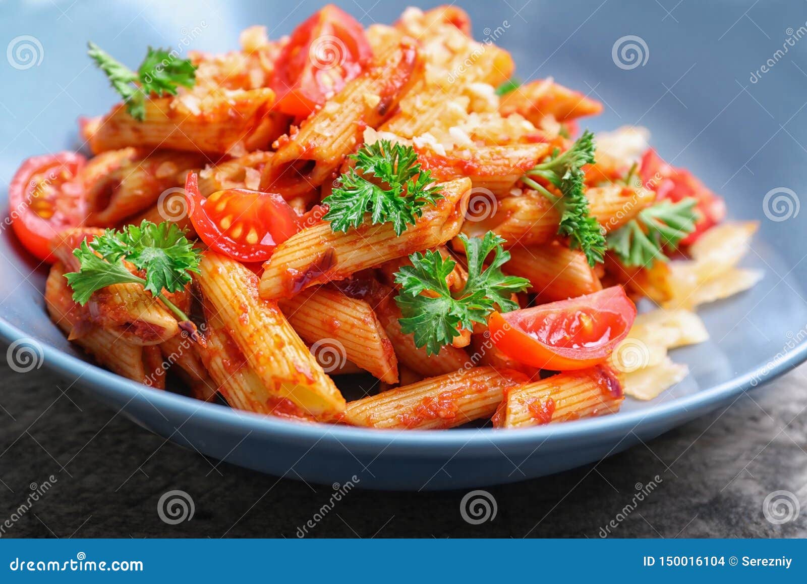 Plate with Delicious Penne Pasta and Garnish on Table, Closeup Stock