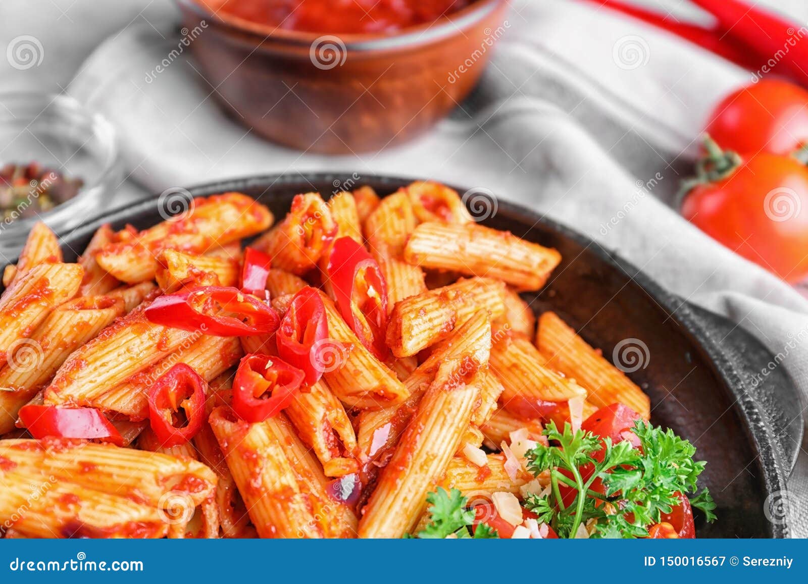 Plate with Delicious Penne Pasta and Garnish on Table, Closeup Stock