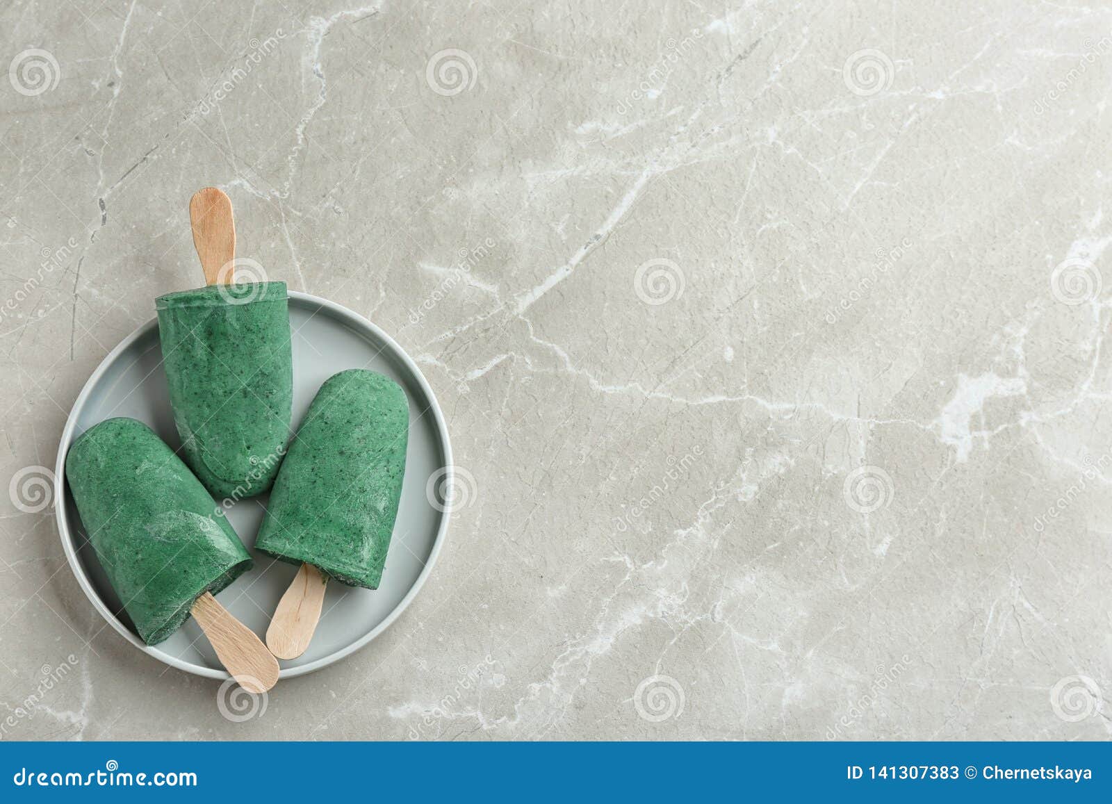 Plate with Delicious Spirulina Popsicles on Grey Background, Top View