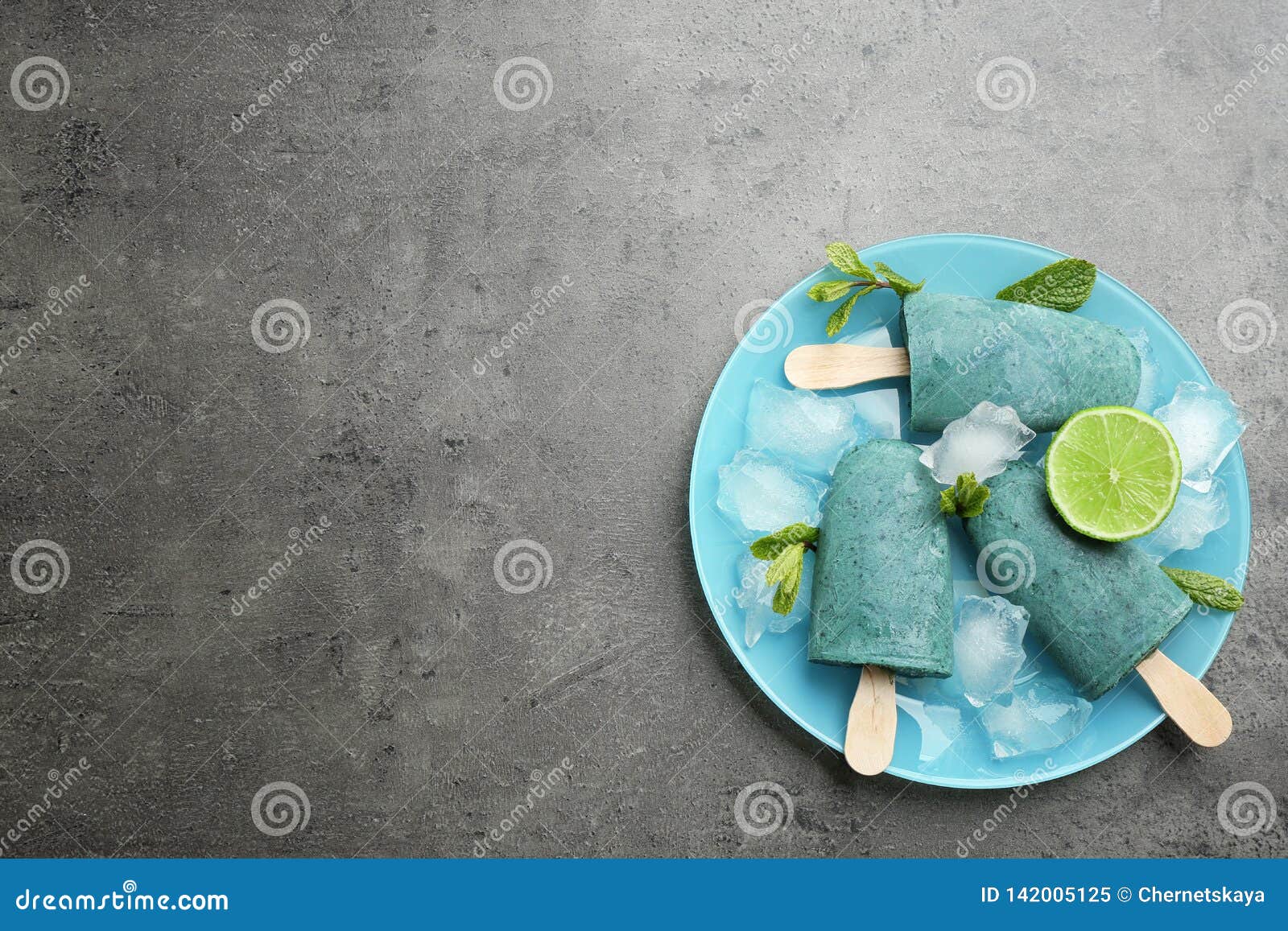 Plate with Delicious Spirulina Popsicles and Lime on Grey Background