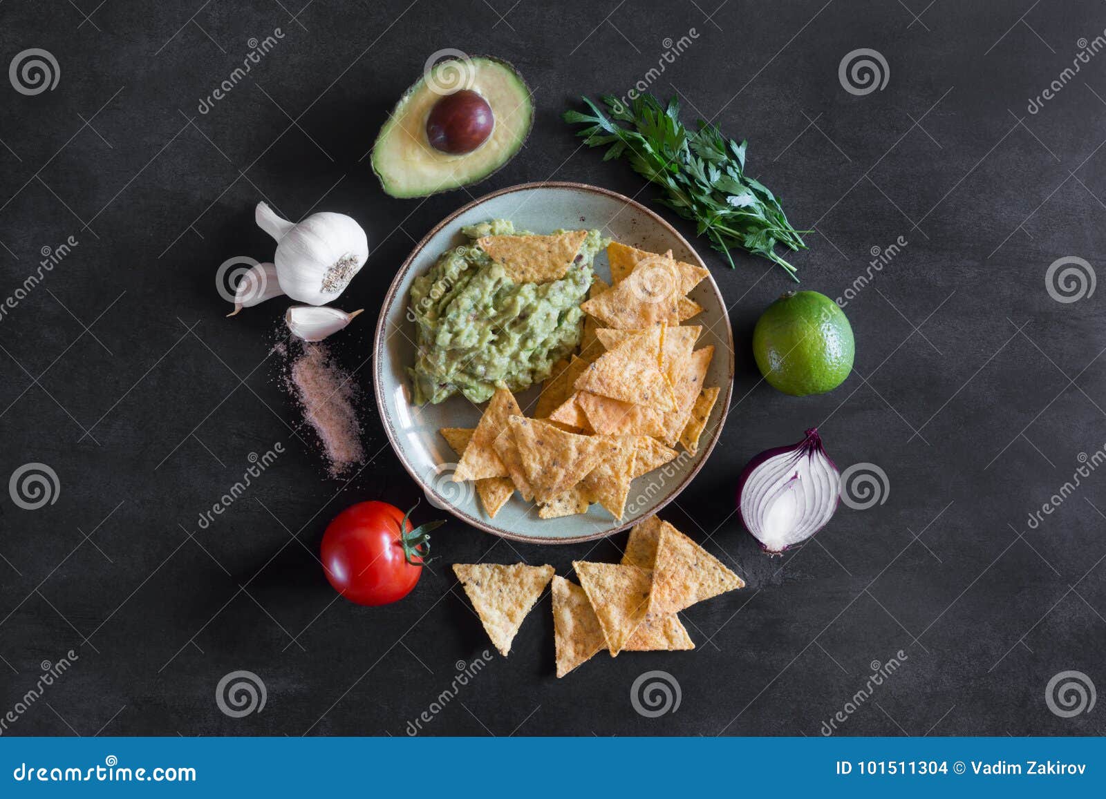 Plate of Guacamole with Tortilla Chips and Ingredients Stock Photo
