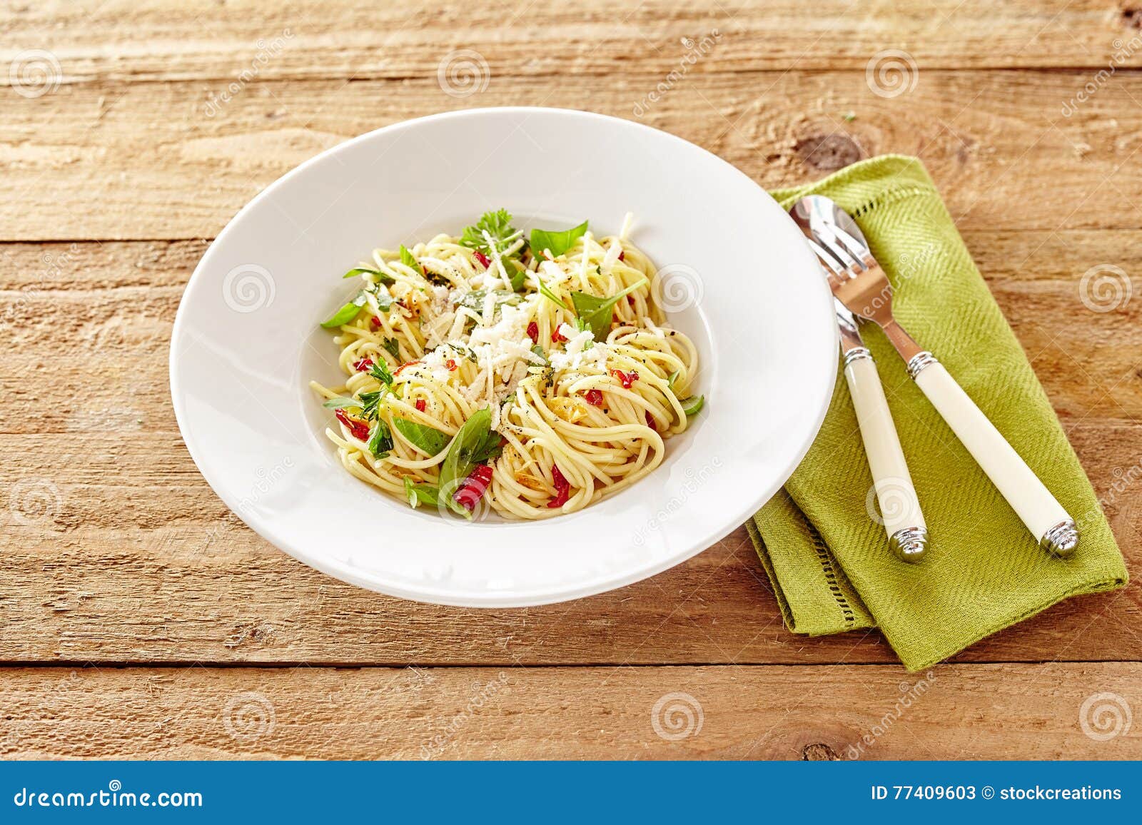 plate of italian spaghetti aglio olio with basil and tomato