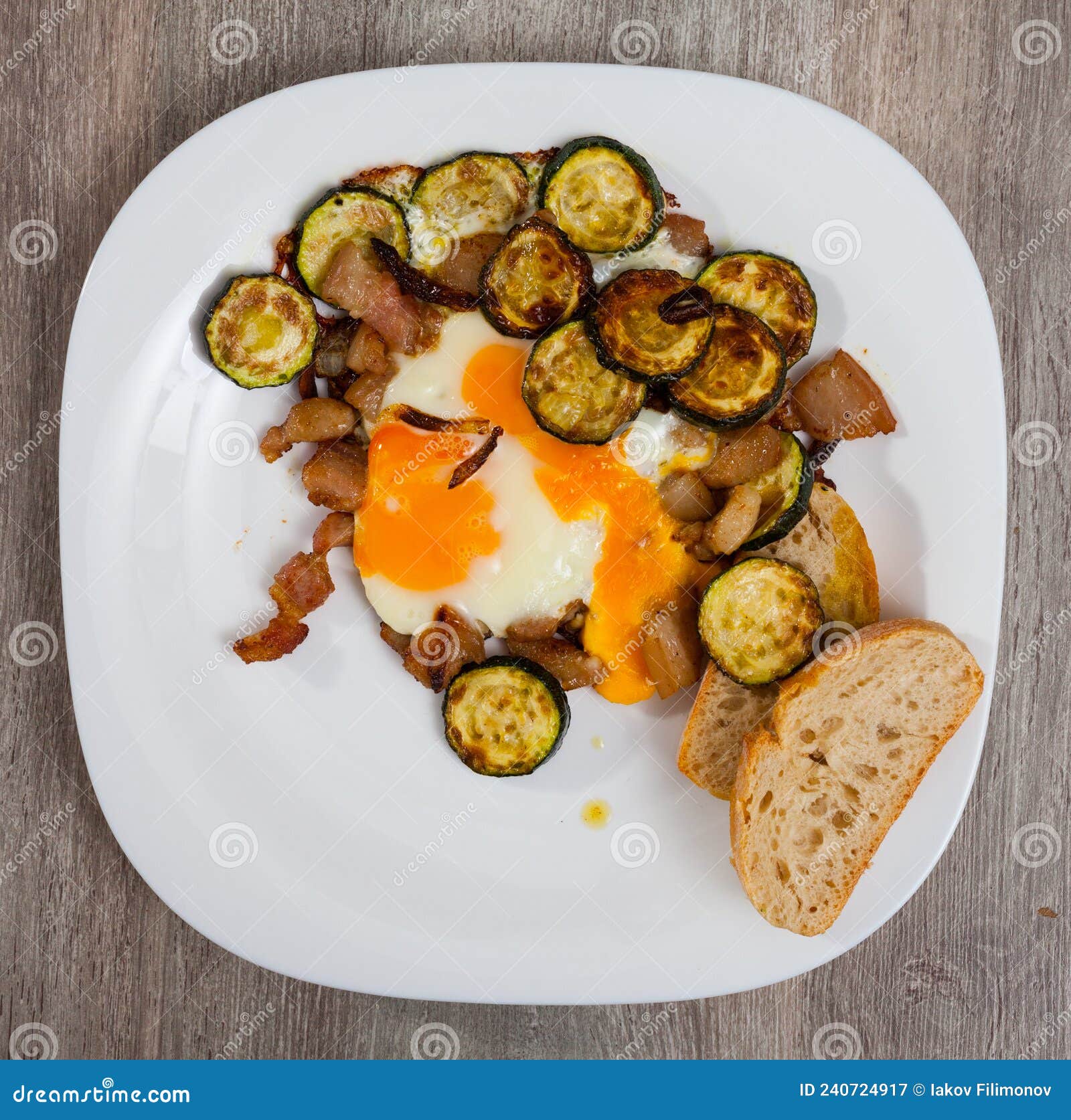 Plate with Scrambled Eggs with Lard and Zucchini at Table on Table