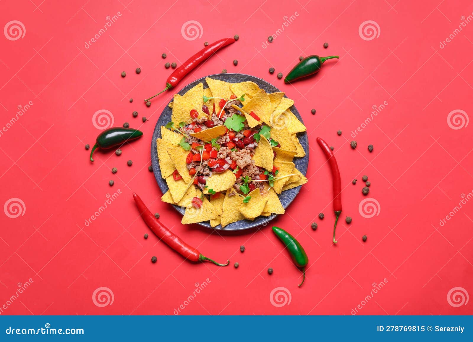 plate with tasty chili con carne and nachos on color background