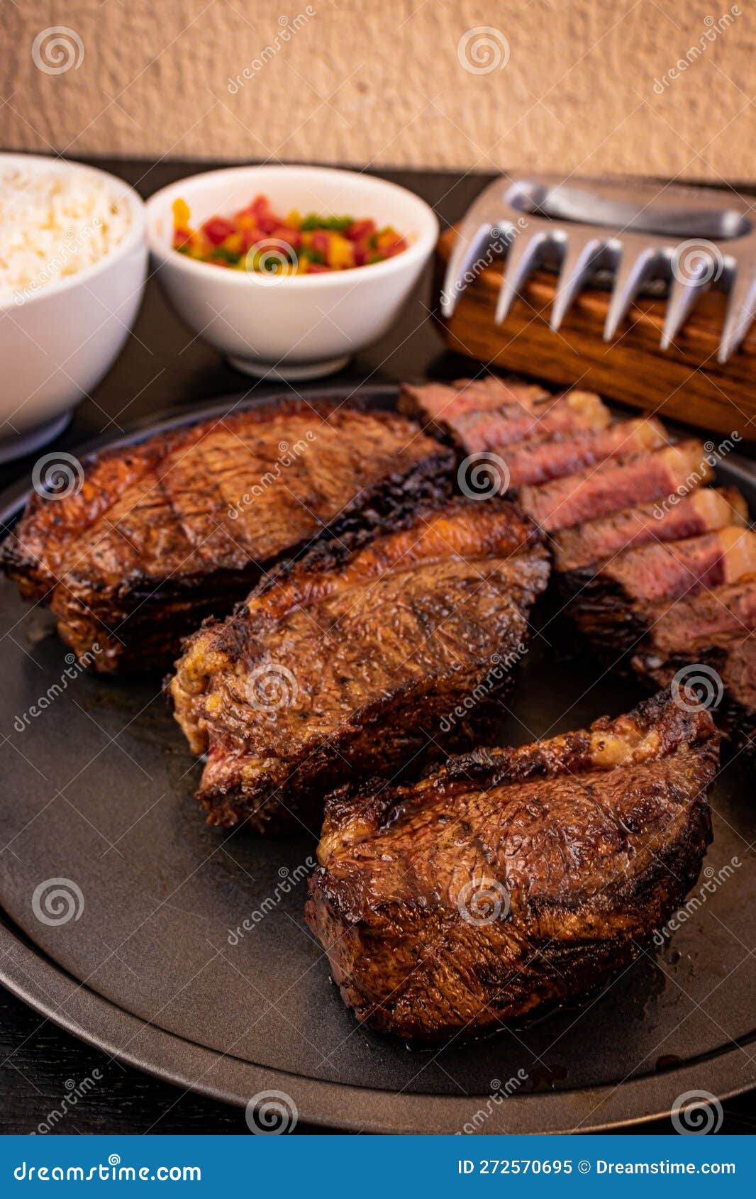 plated assortment of beef steaks and other accompaniments, arranged neatly on a wooden table
