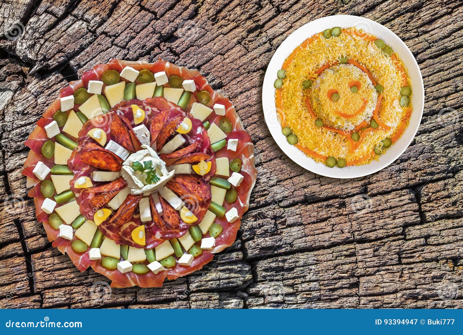 plateful of appetizer dish meze with bowl of russian salad set on old cracked stump top surface serving as picnic table