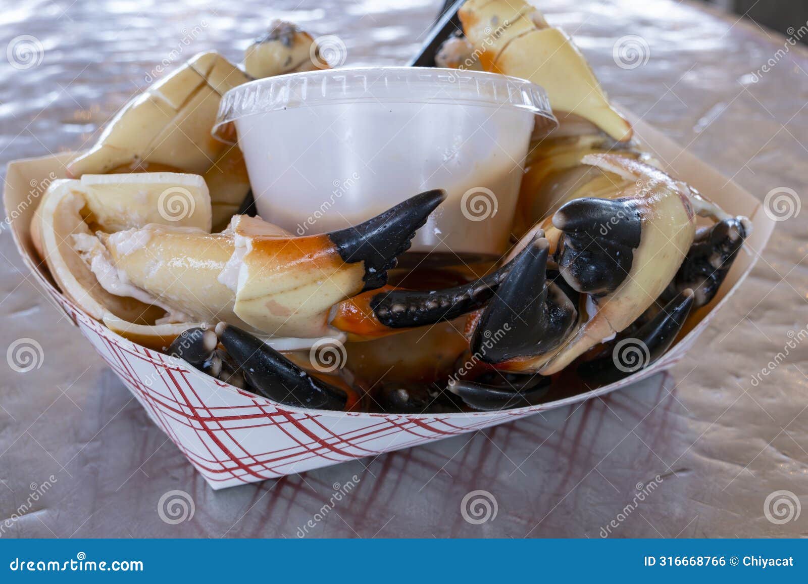 cracked stone crab claws served with a mustard sauce ready to eat