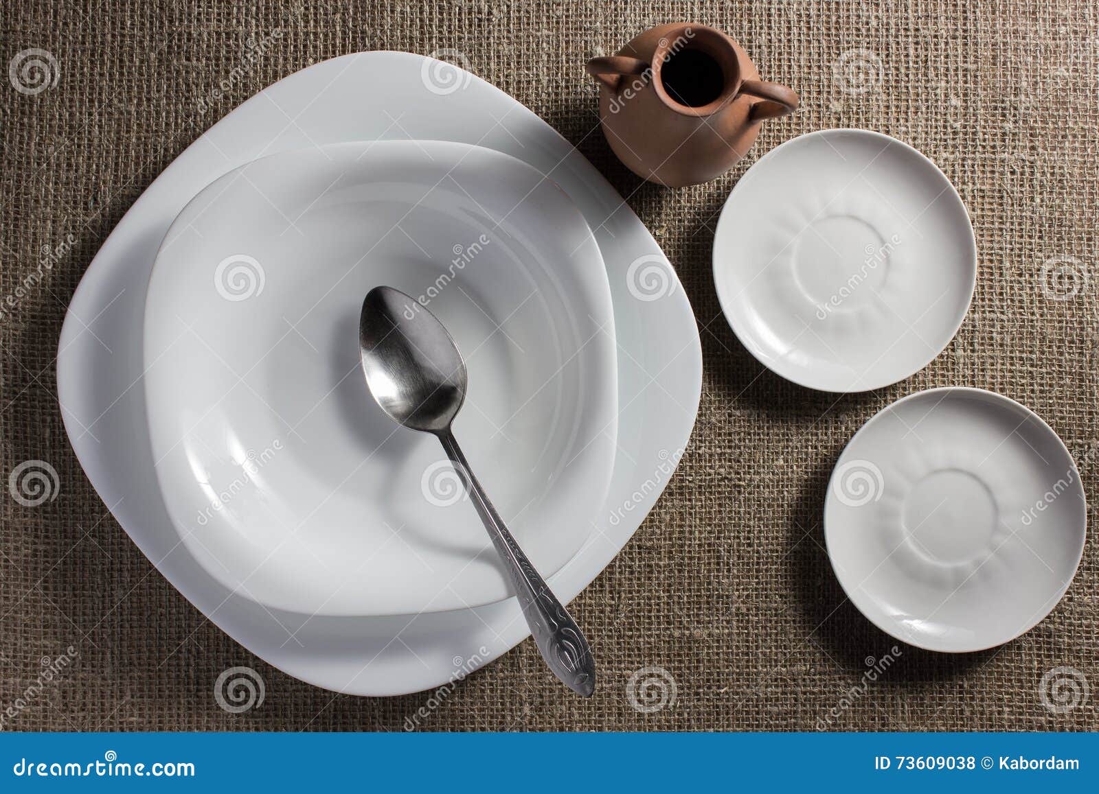 Plates and jug on a table stock photo. Image of sacking 73609038