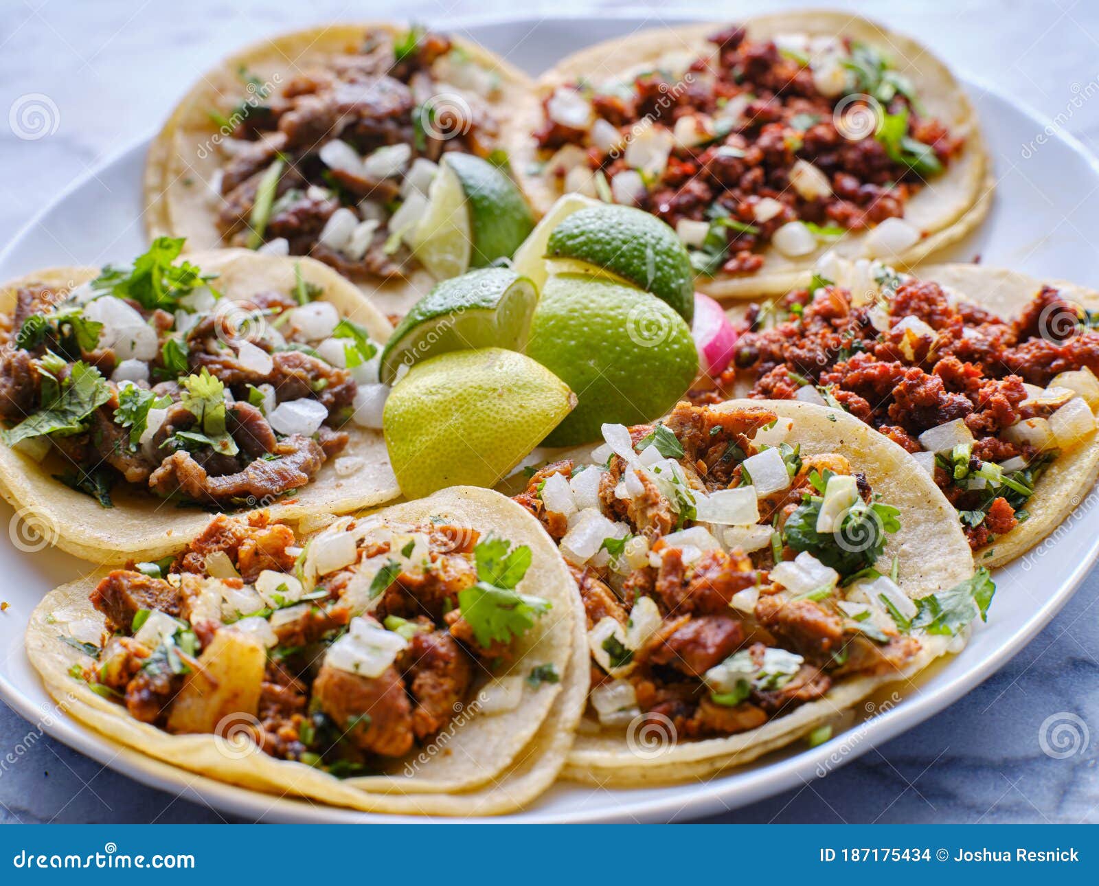 platter of mexican street tacos with carne asada, chorizo, and al pastor in corn tortillas