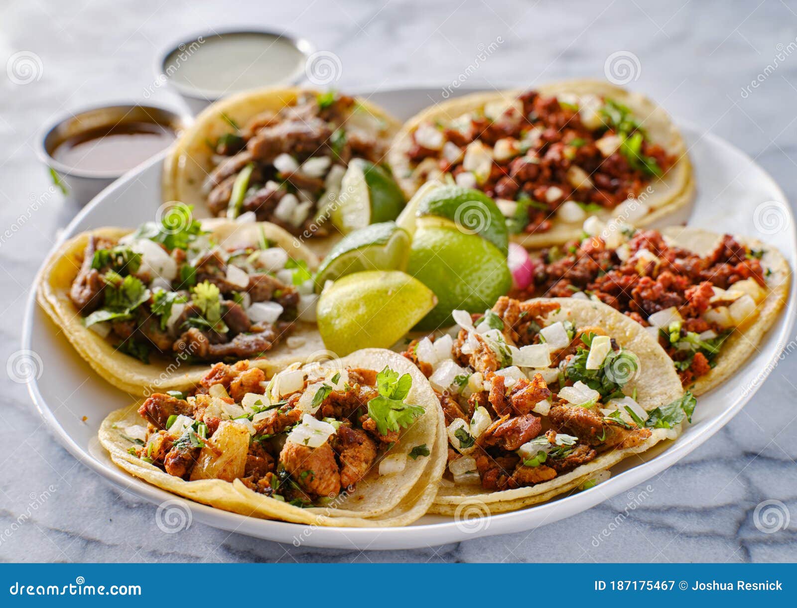 platter of mexican street tacos with carne asada, chorizo, and al pastor in corn tortillas