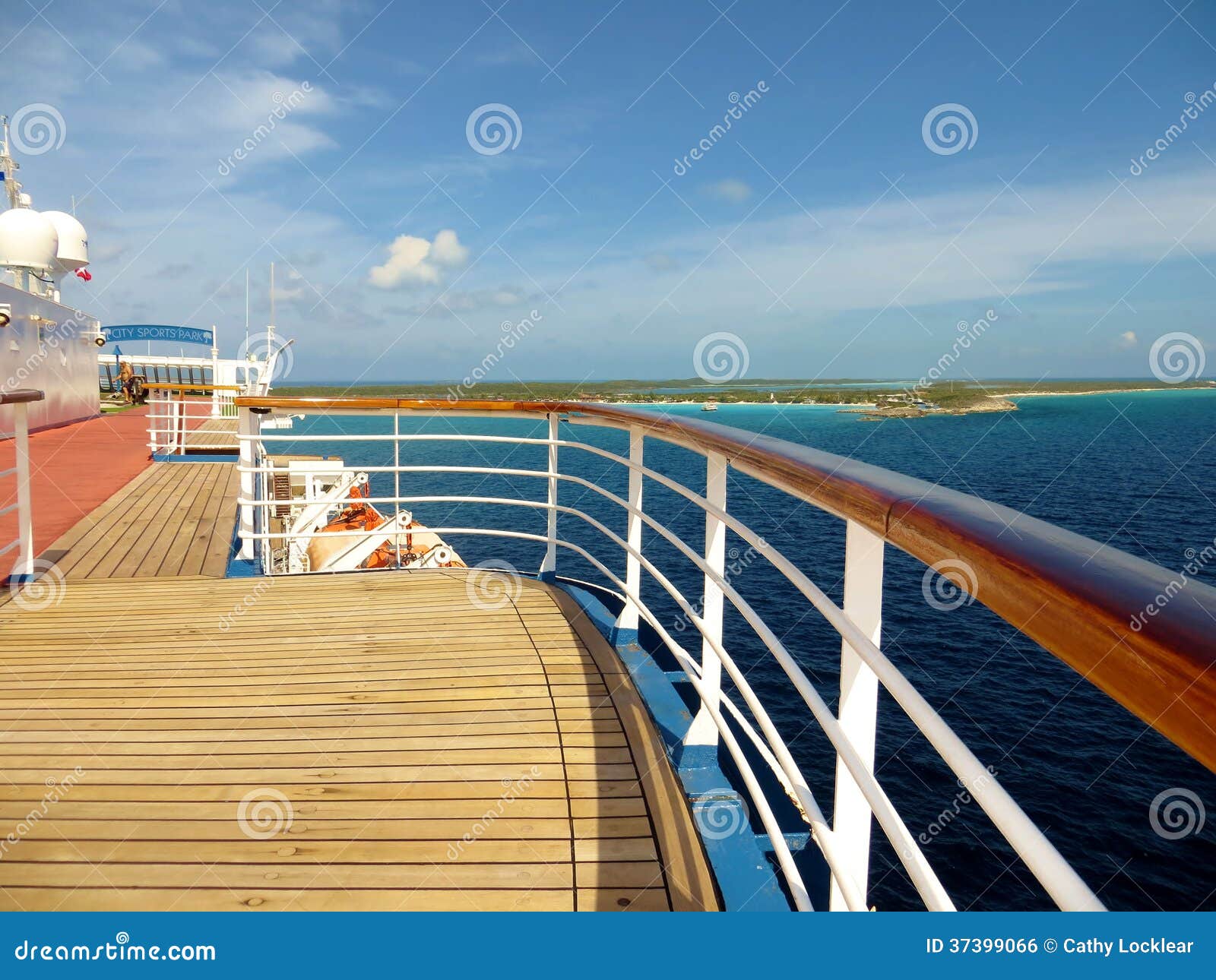 Plattform und Schiene auf einem Kreuzschiff. Foto einer Kreuzschiffplattform und Schiene mit dem Ozean und einer Insel im Hintergrund