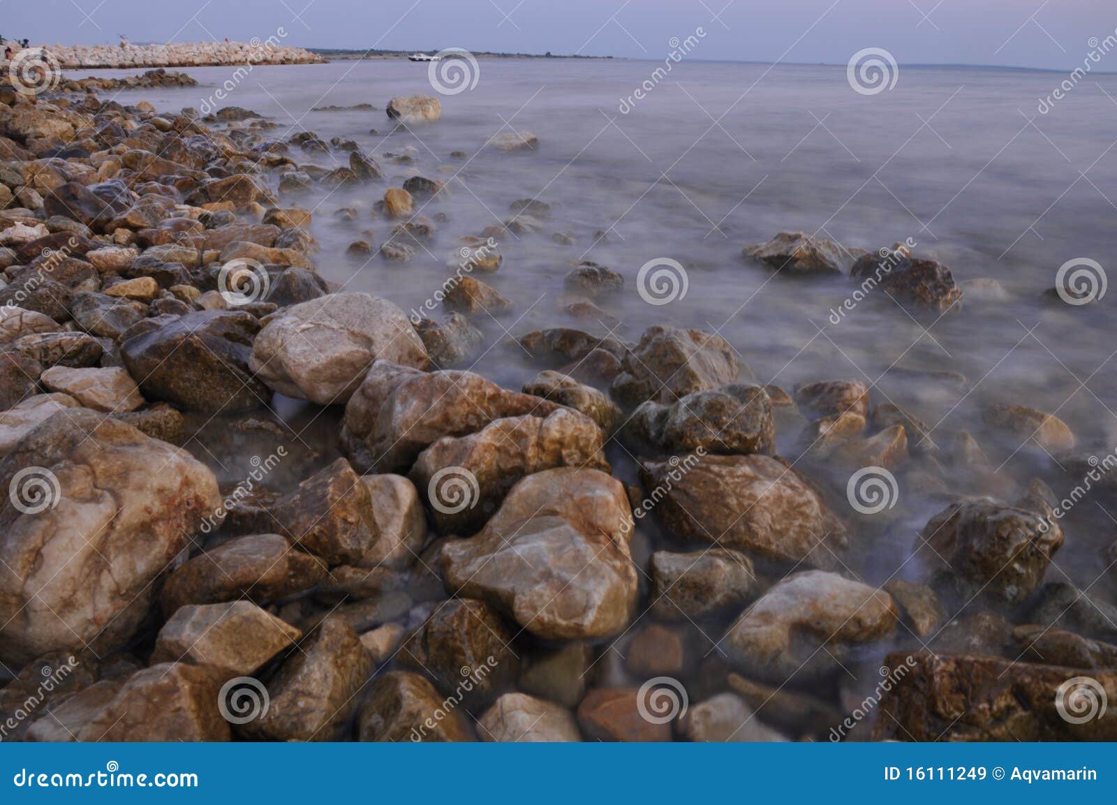 Playa por completo de rocas sostenidas en puesta del sol