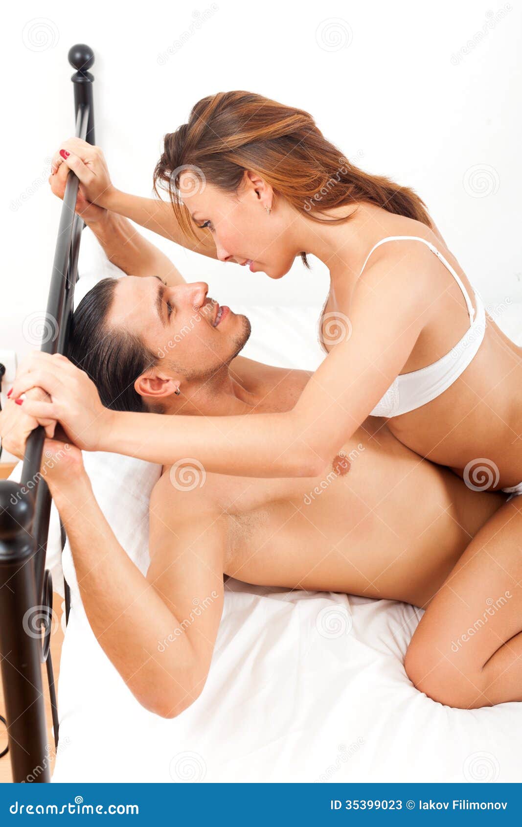 Playfull Adult Couple Having Sex on Bed in Bedroom Interior Stock Image