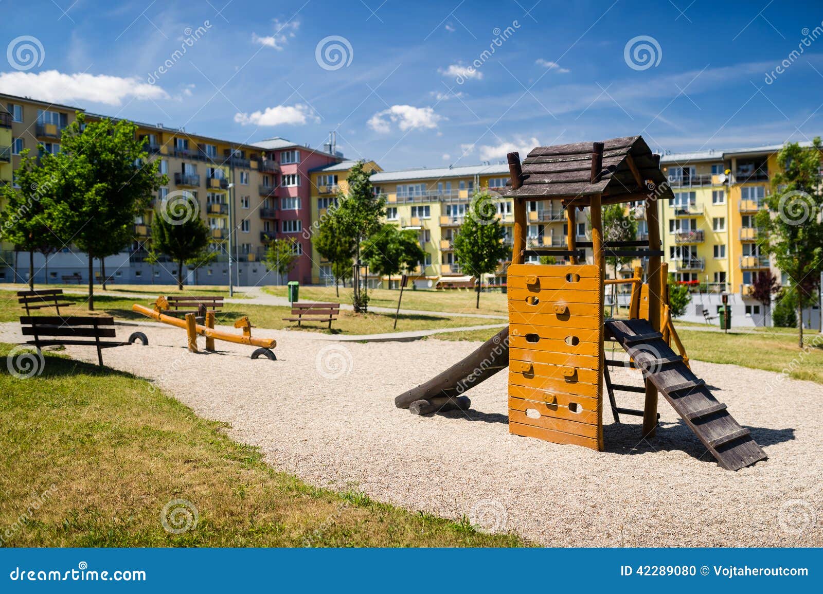 playground in nature in front of row of newly built block of flats