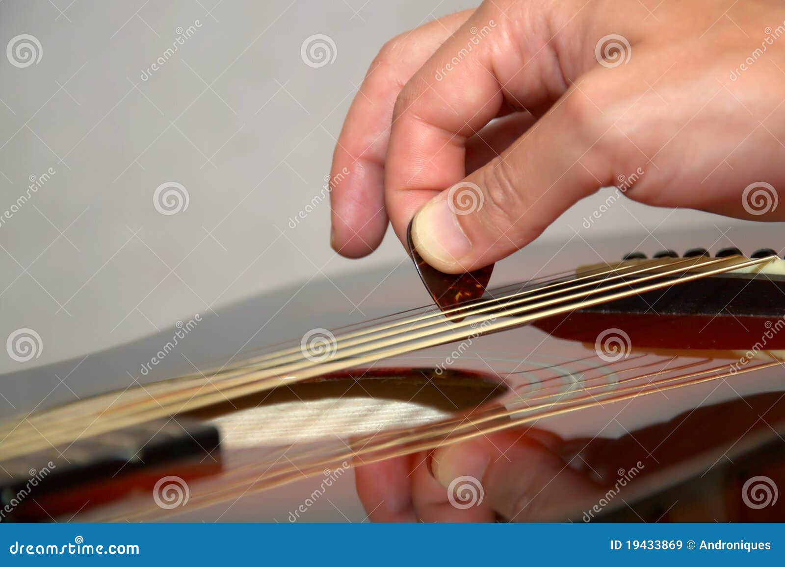 playing acoustic guitar: hand with pick on strings