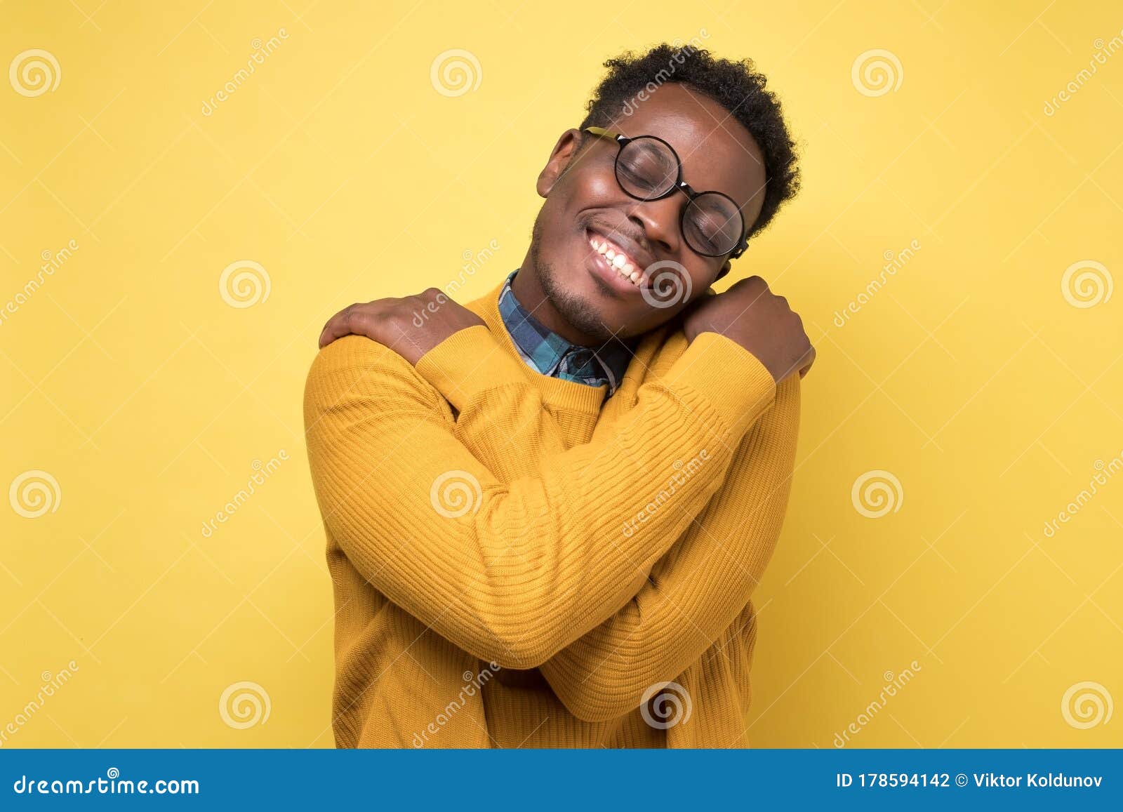 pleased african american man hugs himself, has high self esteem