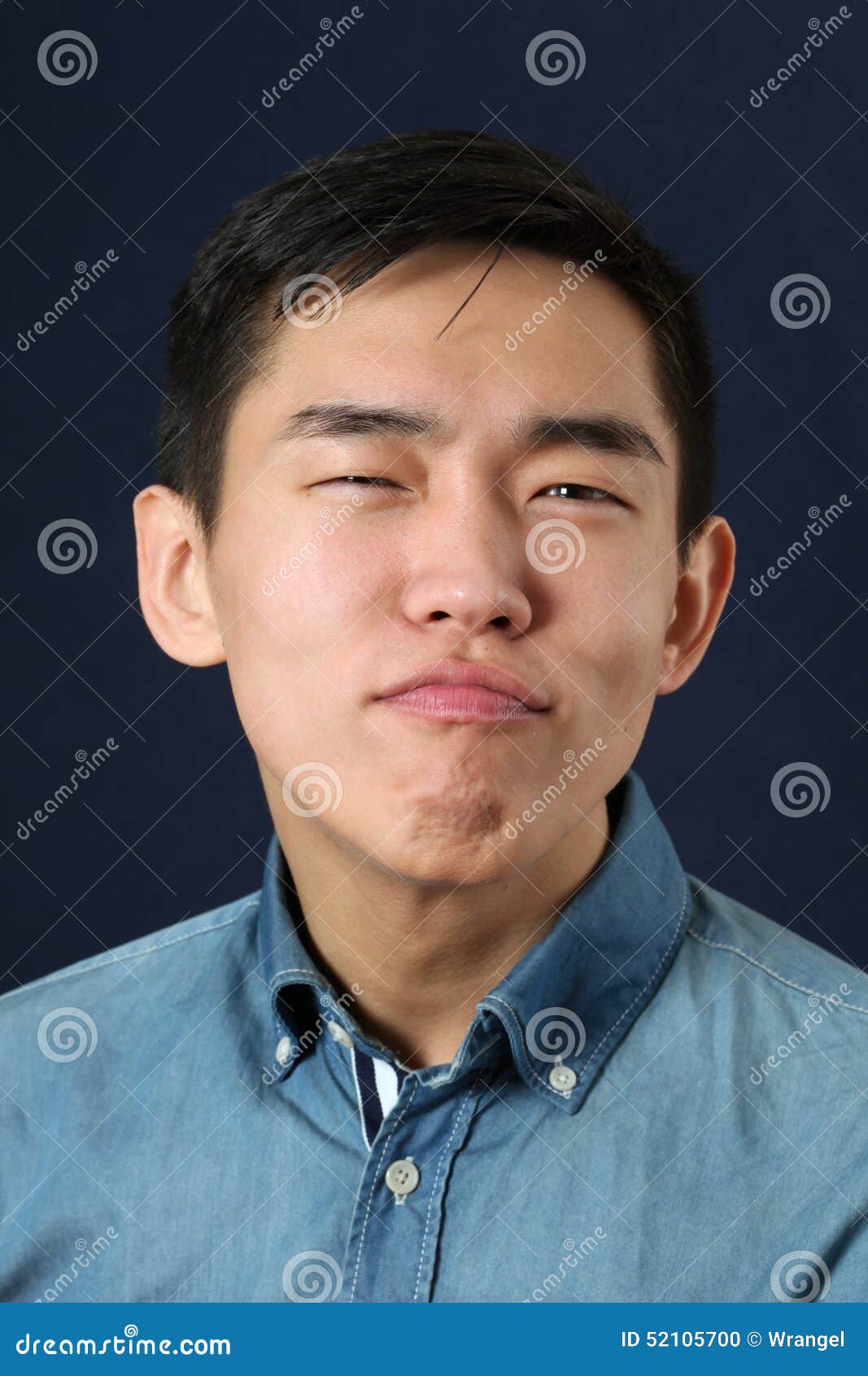 pleased young asian man making face