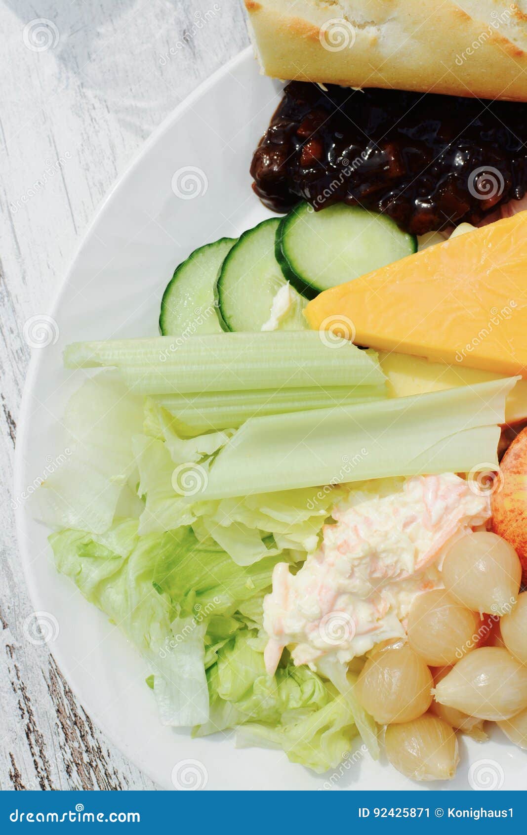 Ploughman ` s Salat mit Käse, Schinken, Kohlsalat, Essiggurke, Kopfsalat, Sellerie, Apfel und einer weißen Rolle