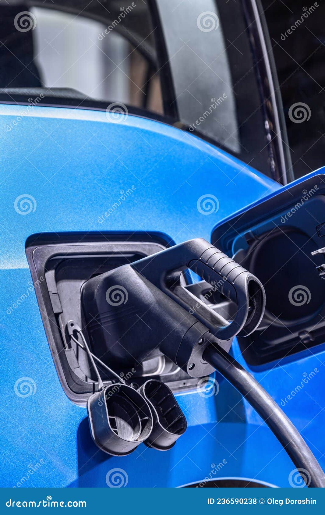 Plug of the Charging Cable Plugged into an Electric Car. Stock Photo